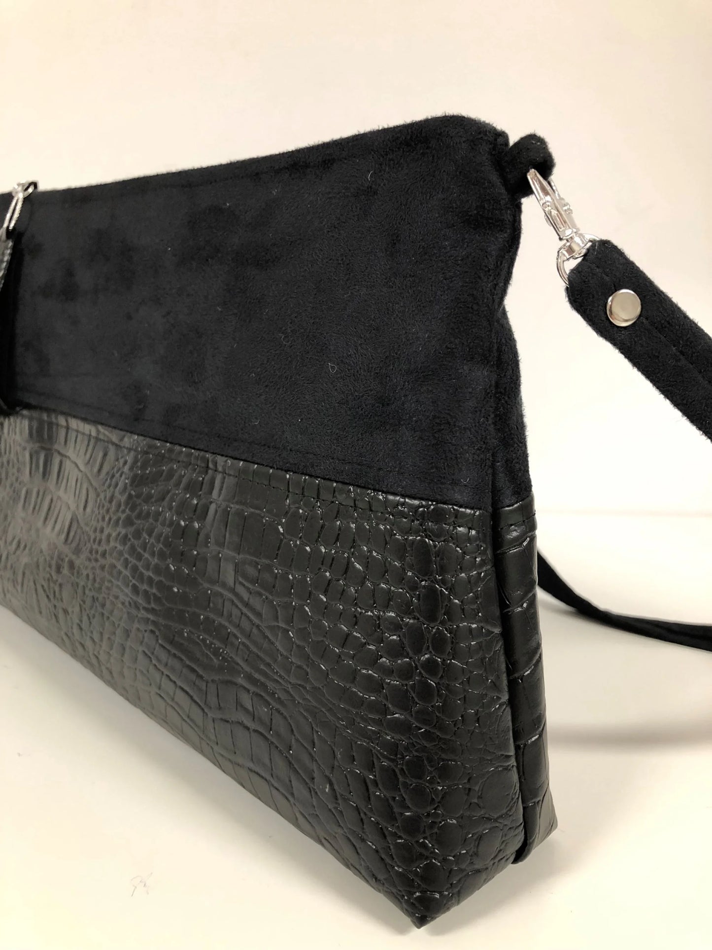 La bandoulière amovible du sac bandoulière Isa noir aspect reptile.