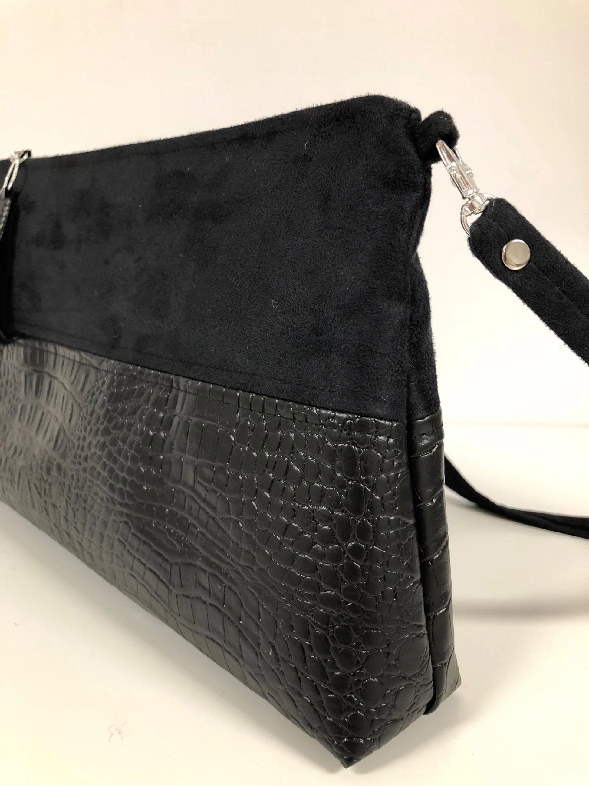 La bandoulière amovible du sac bandoulière Isa noir aspect reptile.
