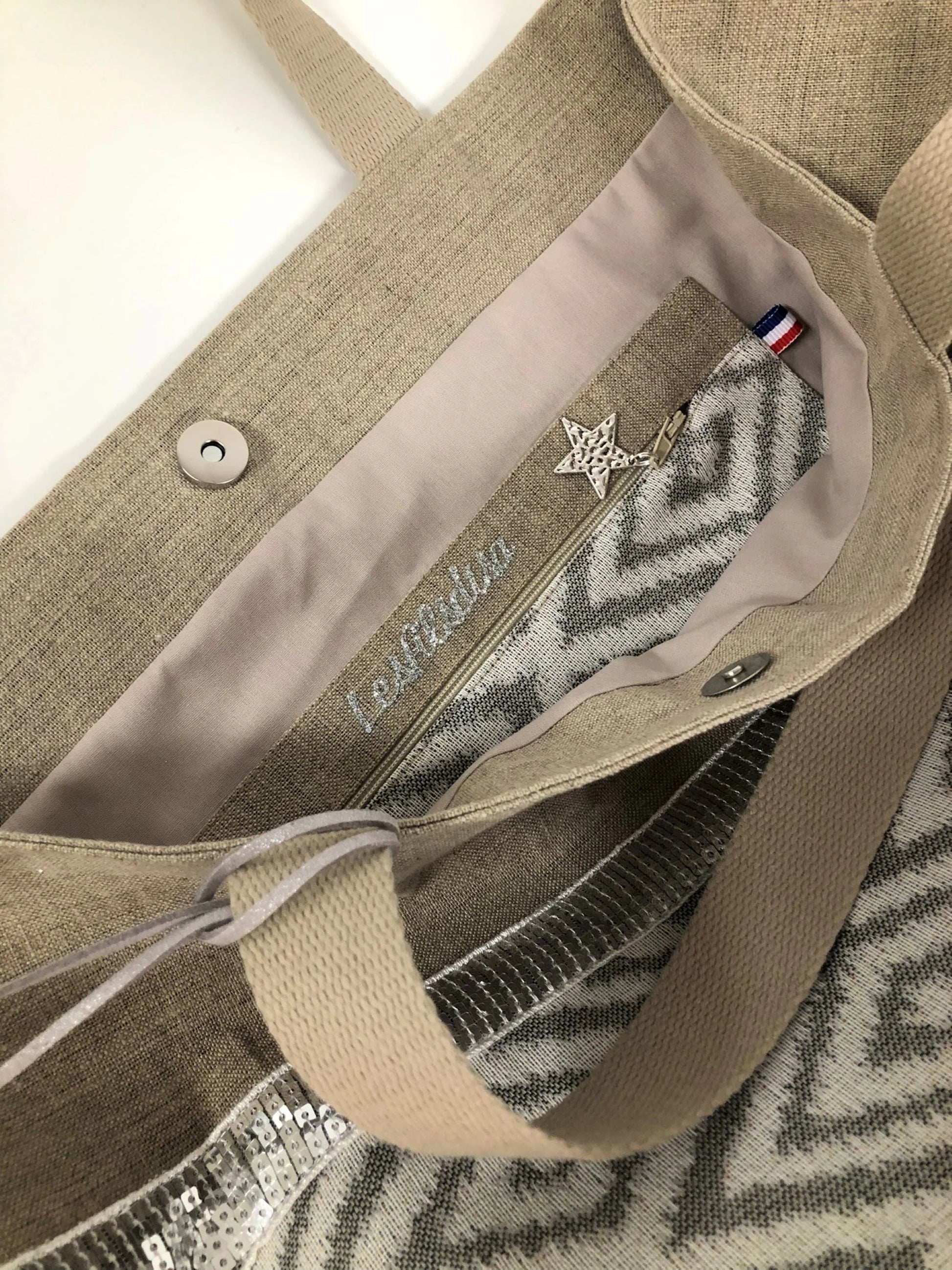 Vue intérieure de la poche du sac cabas Isa en lin à chevrons écrus, avec fermoir magnétique.