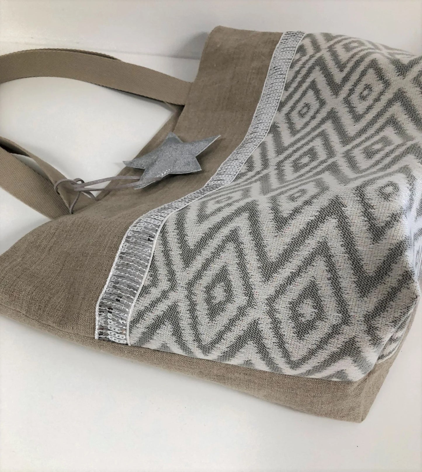 Le sac cabas Isa en lin et chevrons écrus,à paillettes argentées, en face avant.