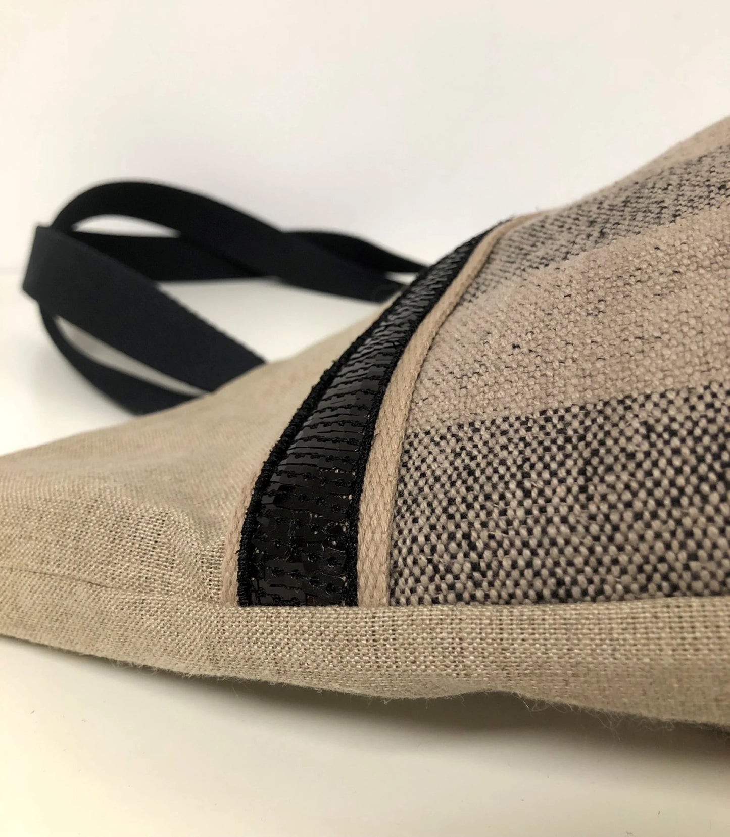Vue détaillée du sac cabas Isa en lin à larges rayures et paillettes noires.