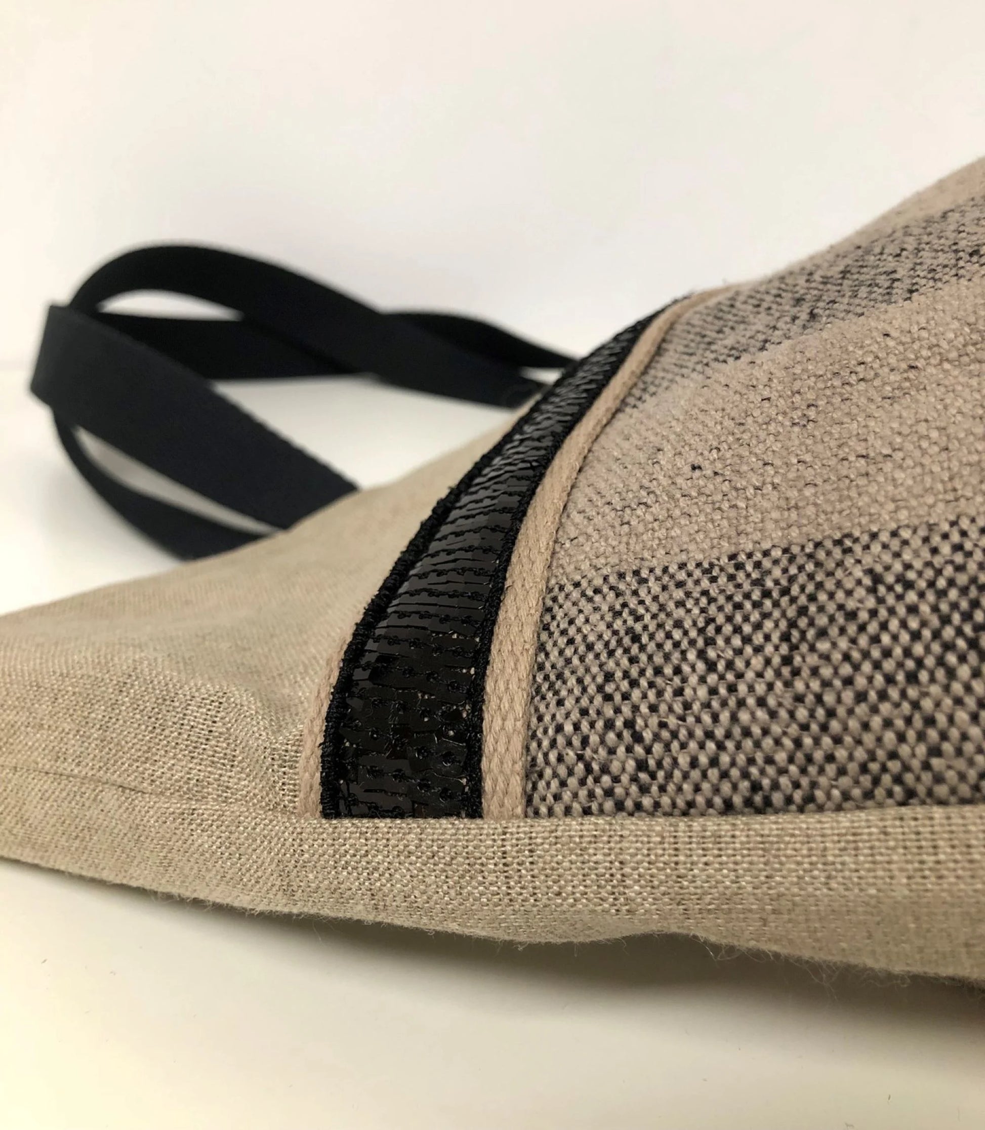 Vue détaillée du sac cabas Isa en lin à larges rayures et paillettes noires.