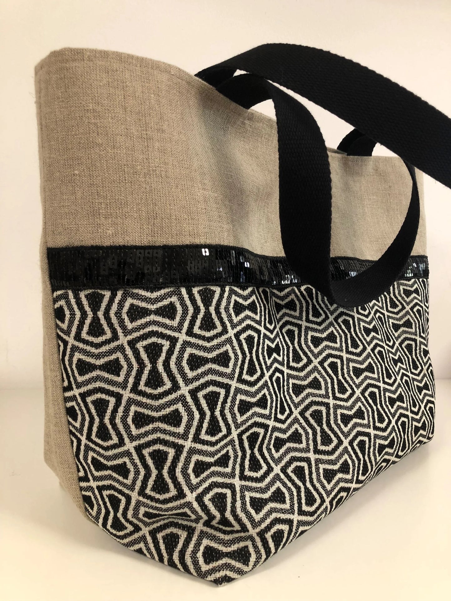 Vue latérale du sac cabas Isa en lin et tissu jacquard à paillettes noires.