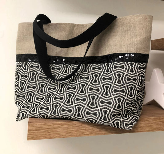 Le sac cabas Isa en lin et tissu jacquard à paillettes noires, face avant.