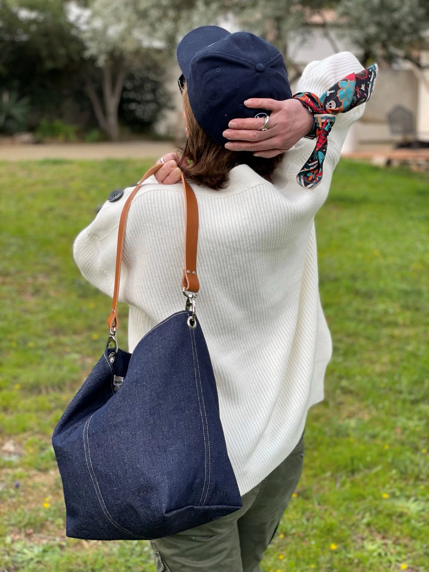 Le sac hobo Lesfilsdisa en denim et cuir porté à l'épaule