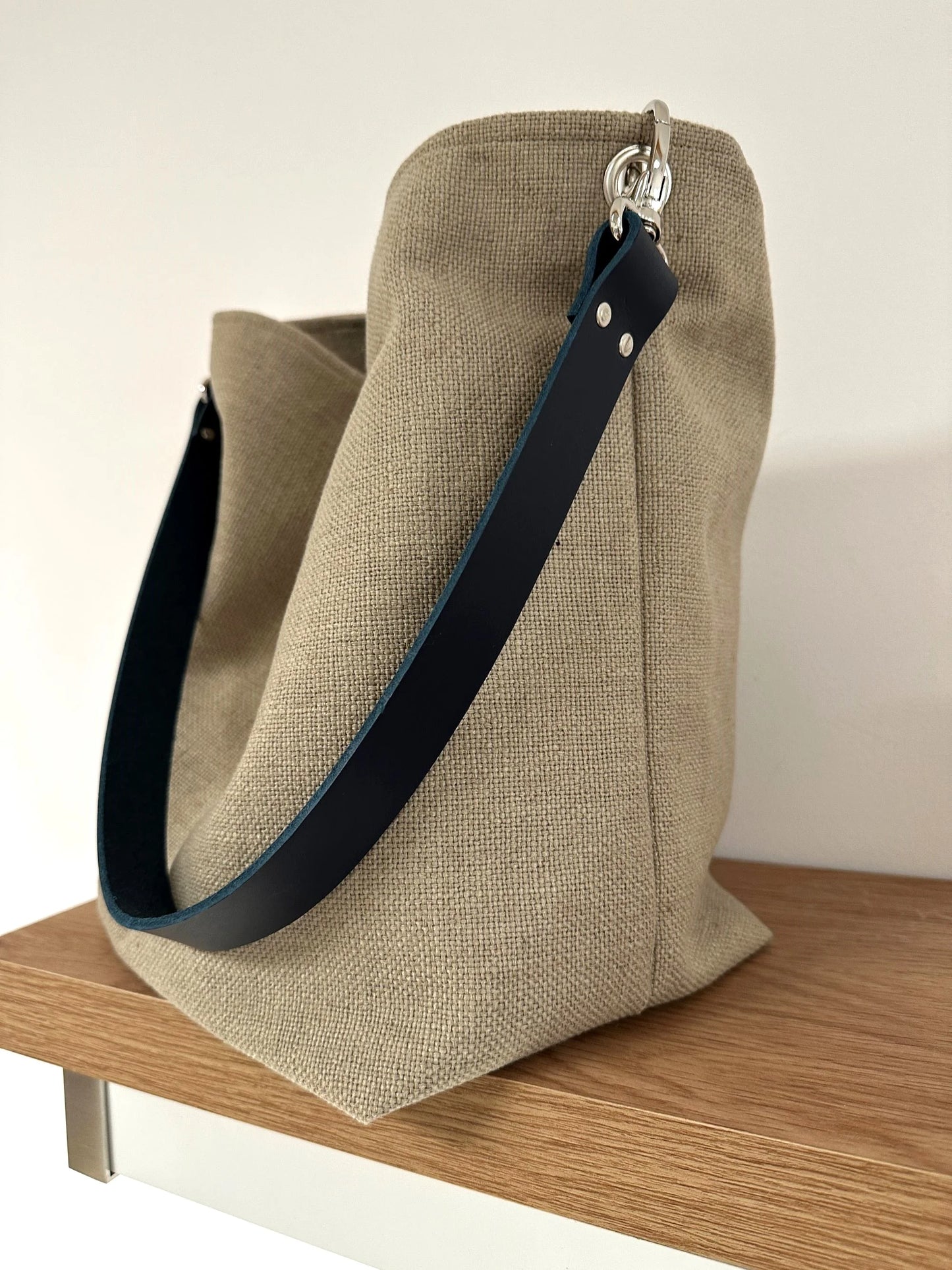 Le sac Hobo en lin beige et son anse en cuir bleu marine amovible