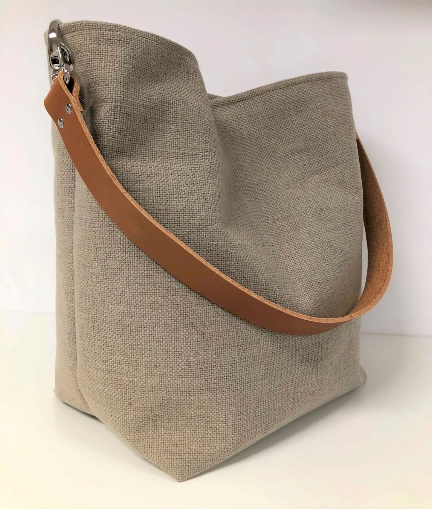 Le sac hobo en lin beige et anse en cuir fauve.