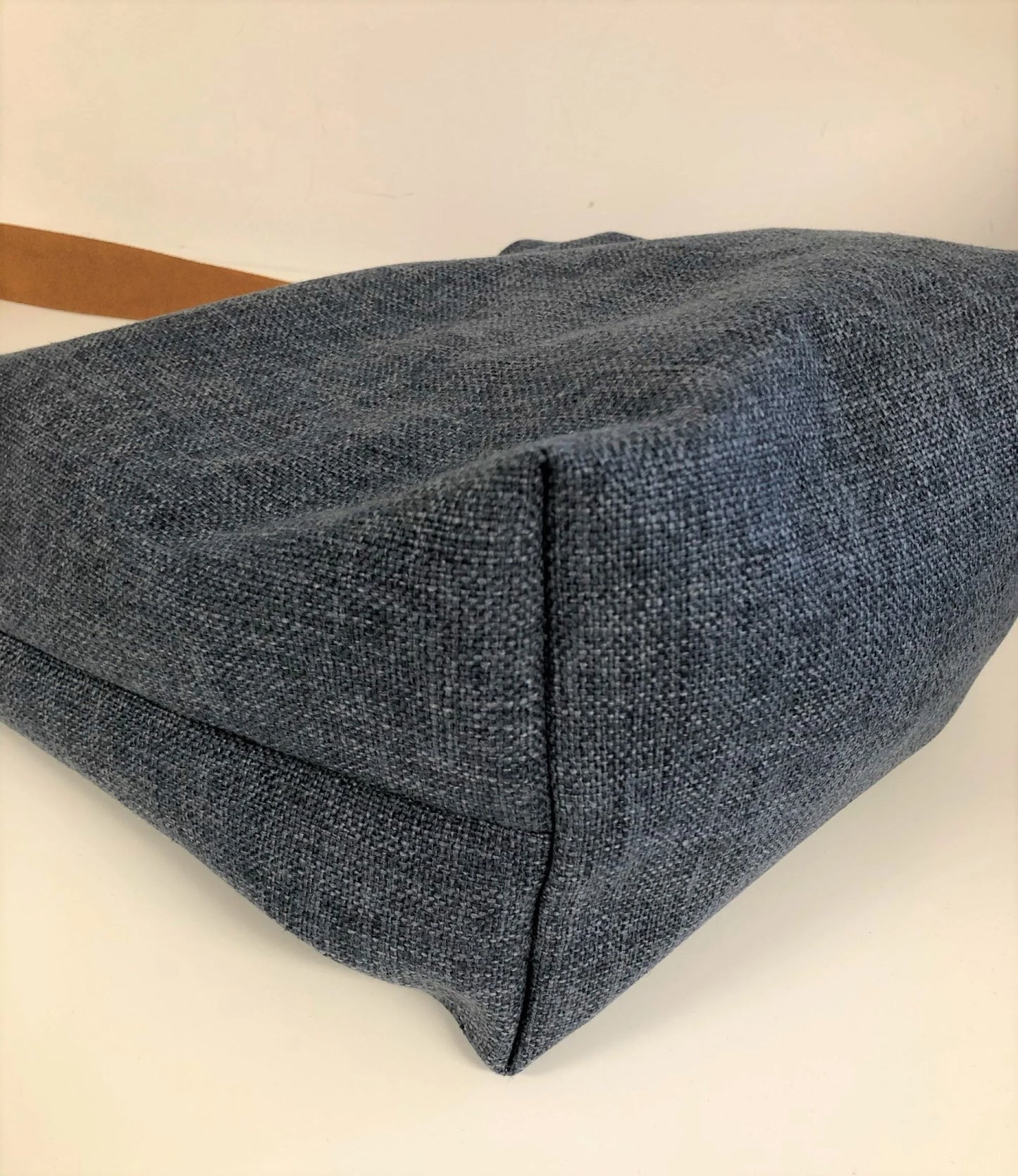 Le fond du sac Hobo en lin bleu et anse en cuir fauve ou marron.
