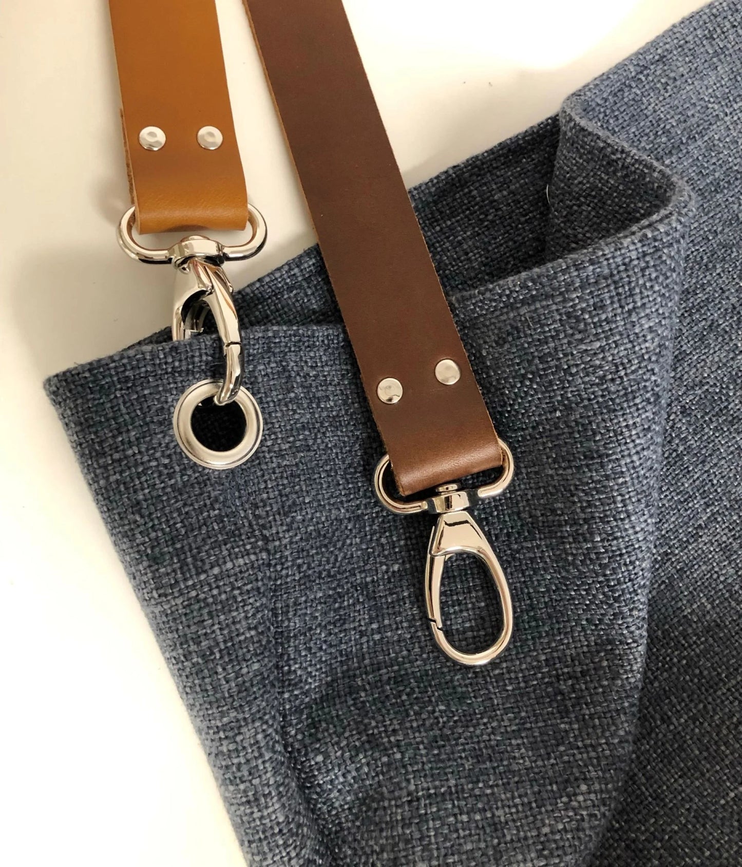 Le sac Hobo en lin bleu et anse en cuir fauve ou marron.
