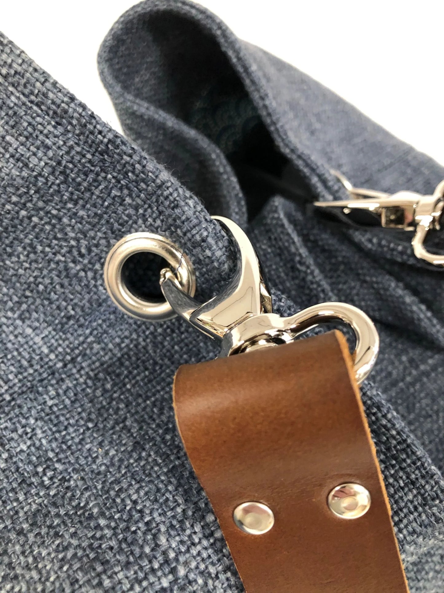 Le sac Hobo en lin bleu et anse en cuir marron.