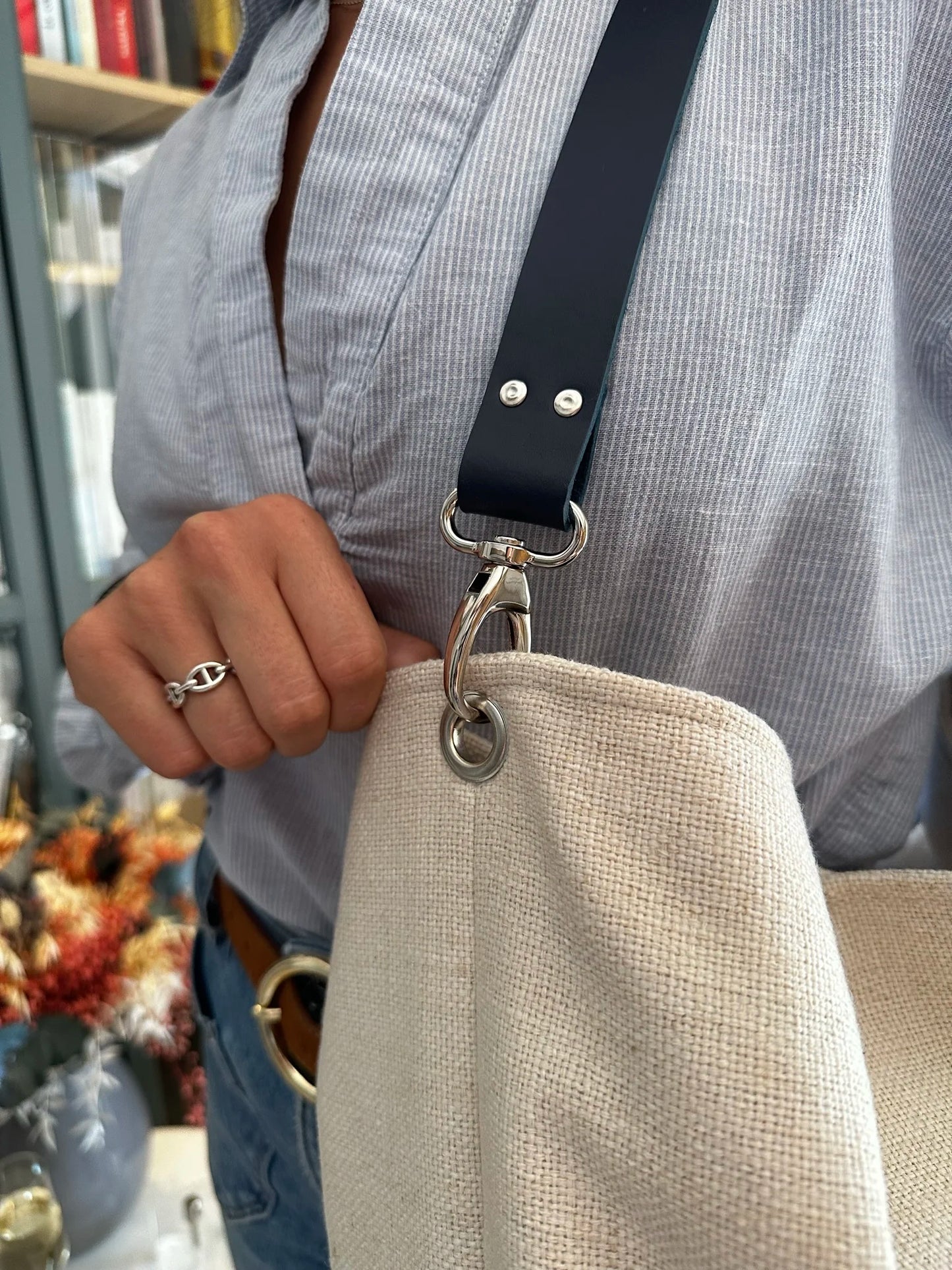 Vue de détail de l'anse en cuir bleu marine du sac Hobo Lesfilsdisa en lin ivoire