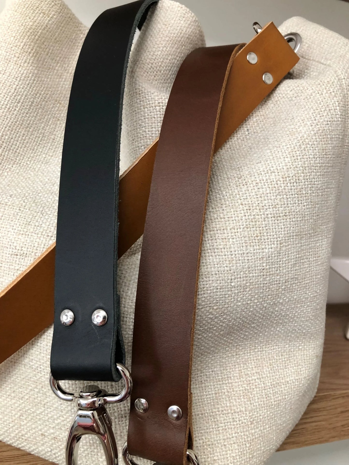 Les anses en cuir du sac Hobo en lin ivoire.