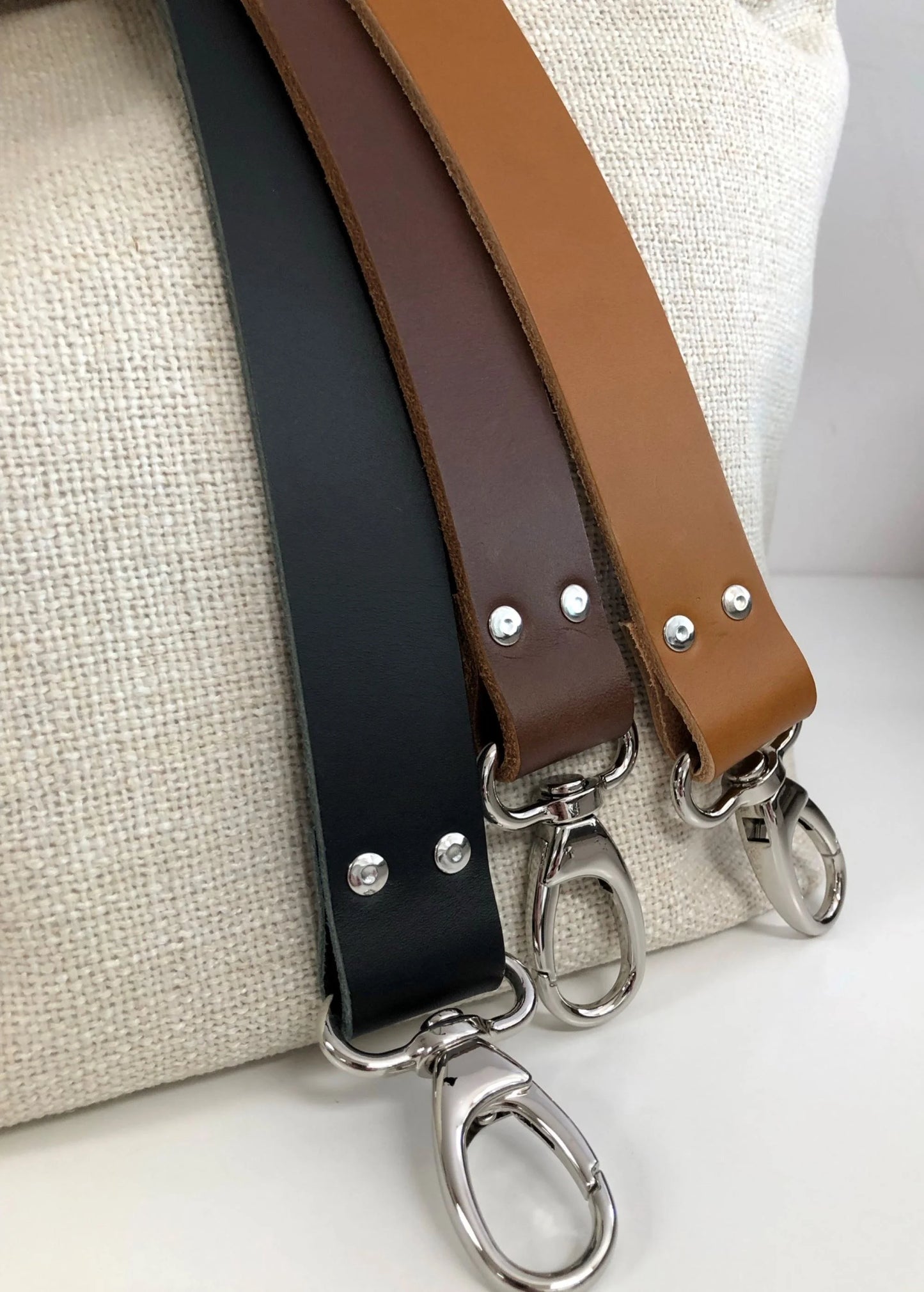 Les trois couleurs de cuir du sac Hobo en lin ivoire.