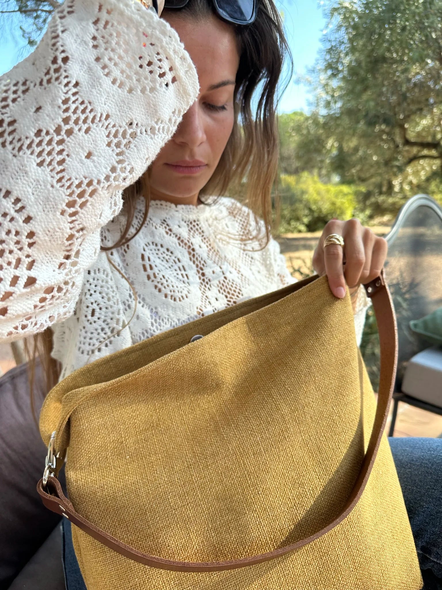Jeune femme avec le sac hobo en lin jaune moutarde et son anse en cuir marron amovible.