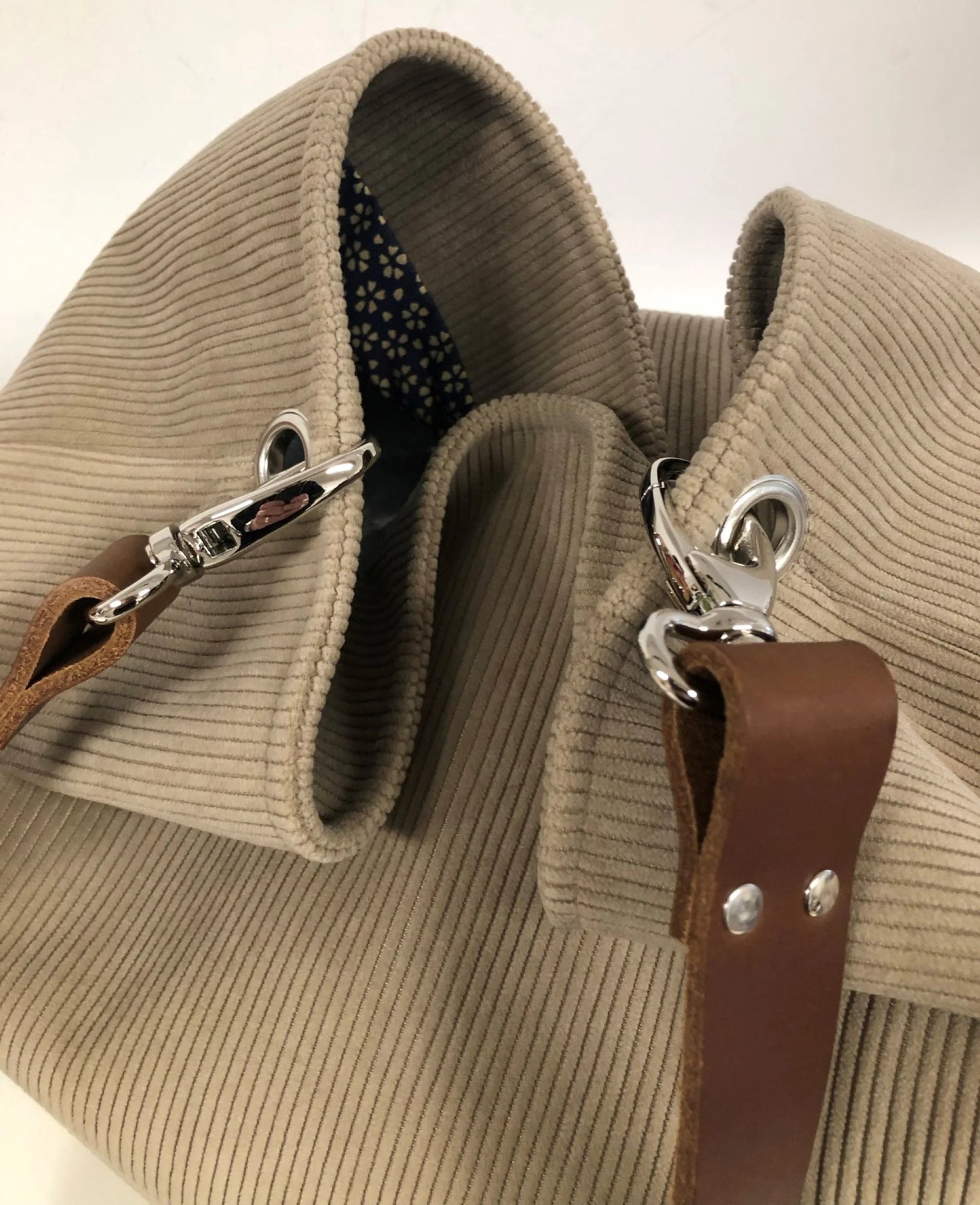Vue de détail de l'anse en cuir marron accrochée au sac hobo Lesfilsdisa en velours côtelé beige
