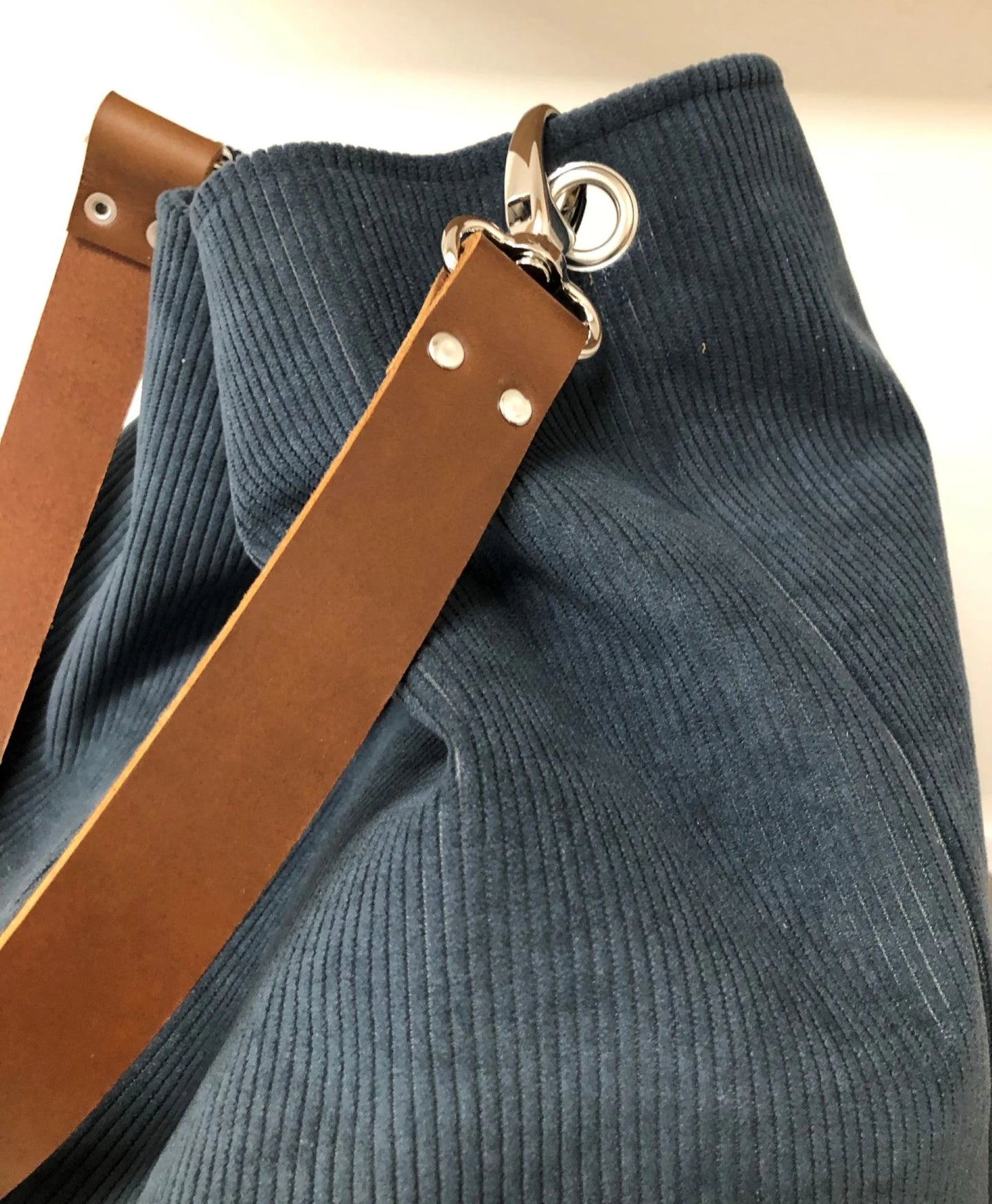 Détail de l'anse en cuir du sac hobo Lesfilsdisa en velours bleu canard