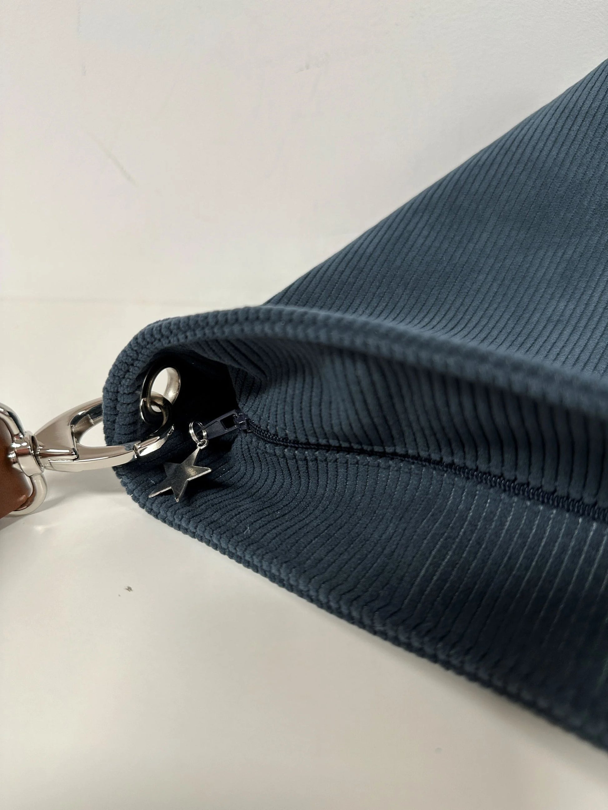 Le sac Hobo fermé par fermeture à glissière, ici visualisé sur le sac Hobo en velours cotelé bleu canard.
