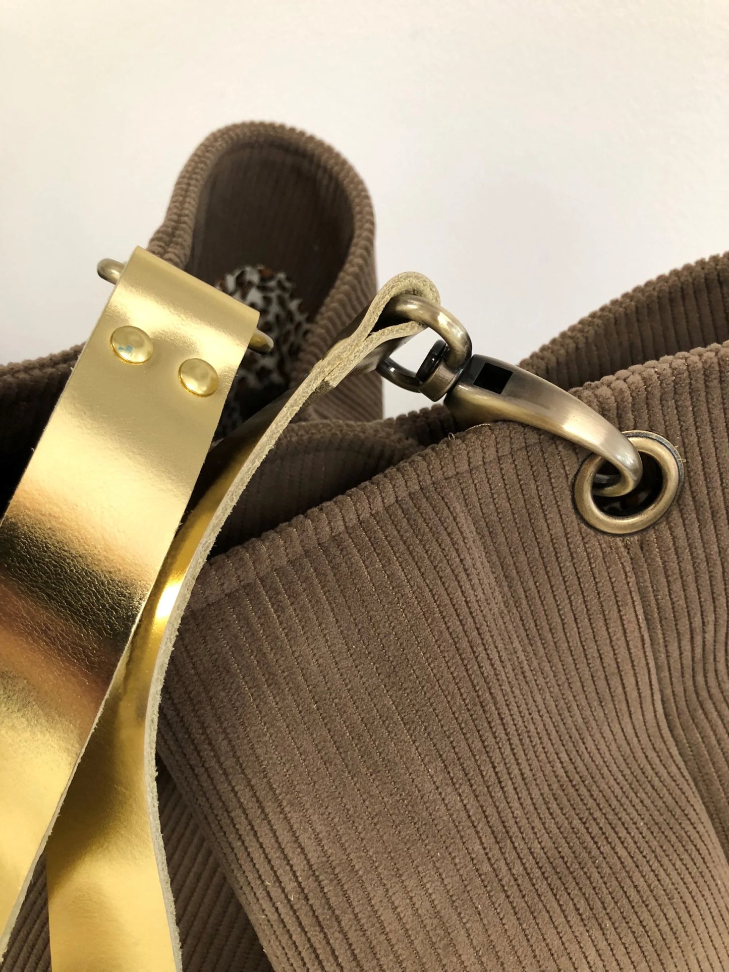 Vue détaillée du sac hobo en velours cotelé marron chamois et son anse en cuir doré