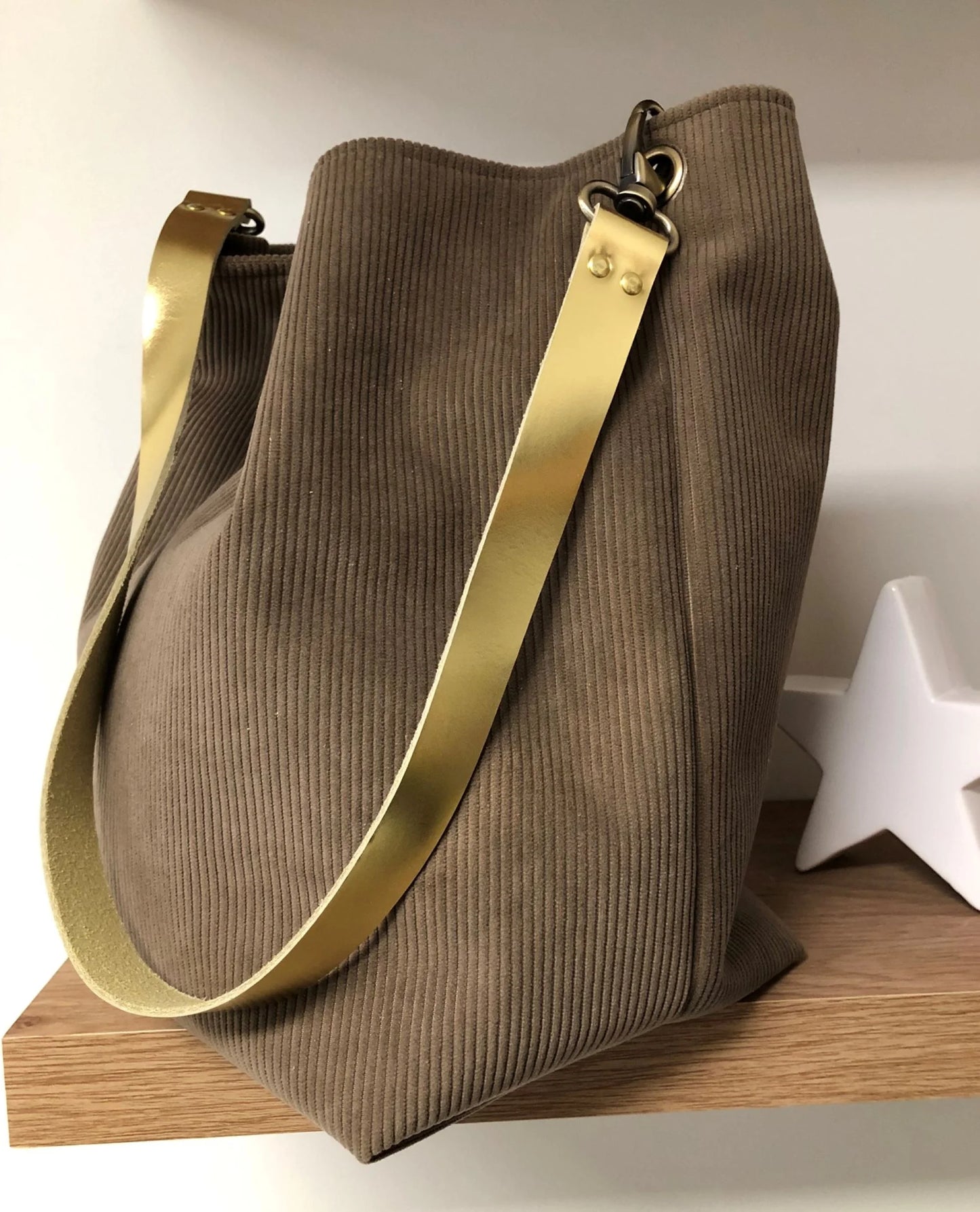 Le sac hobo en velours cotelé marron chamois et son anse en cuir doré