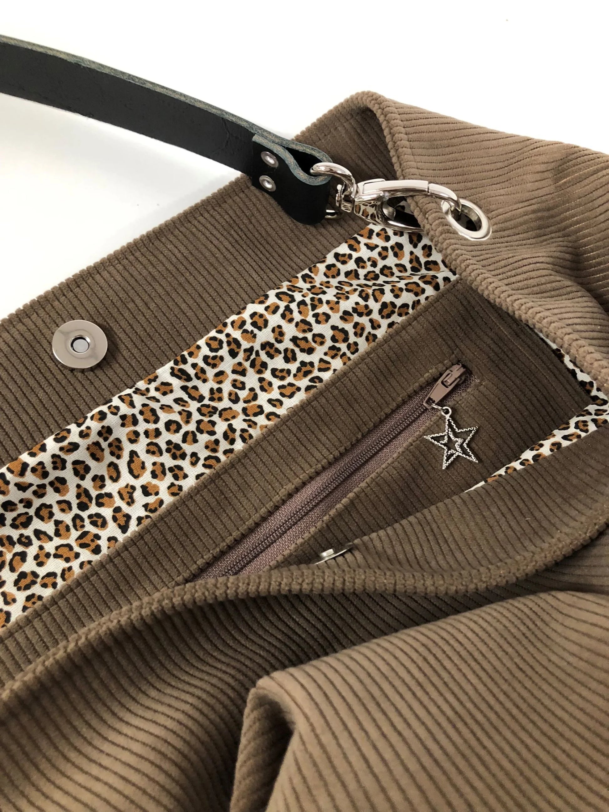 la poche intérieure zippée du sac hobo en velours cotelé marron chamois et son anse en cuir noir.