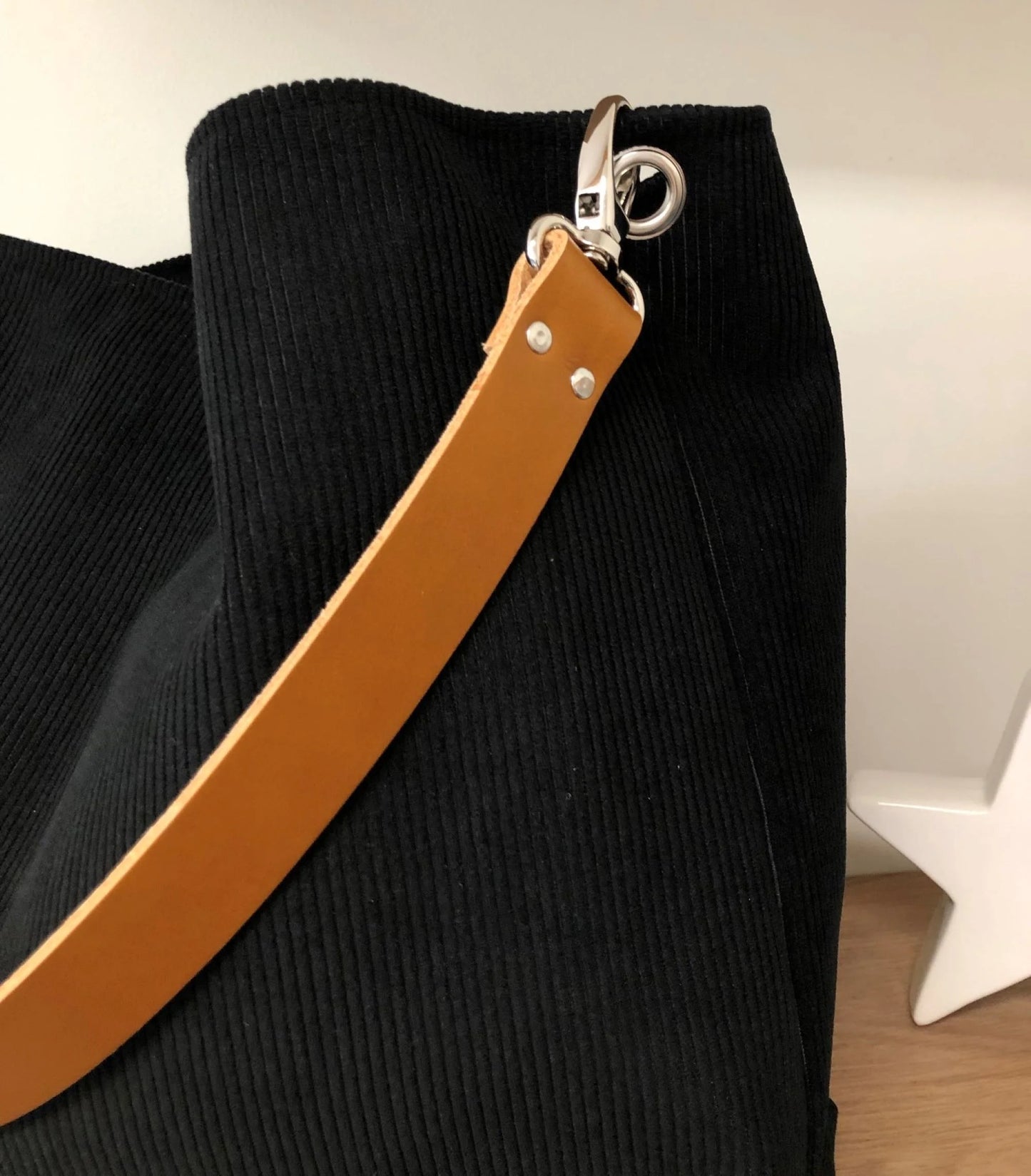 Vue de détail de l'anse en cuir fauve du sac hobo Lesfilsdisa en velours cotelé noir