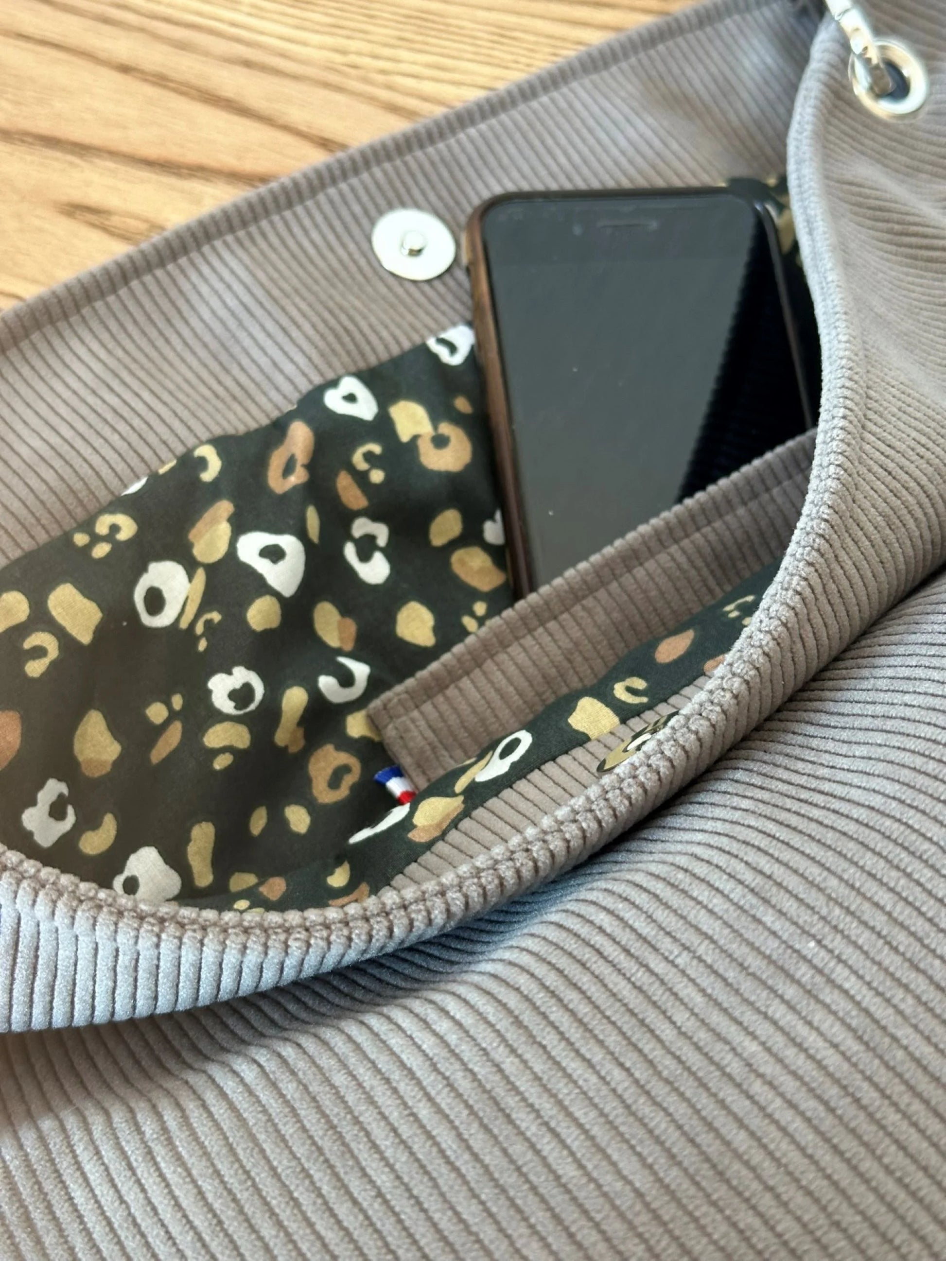 La poche plaquée intérieure du sac Hobo en velours cotelé taupe, pratique pour votre téléphone.