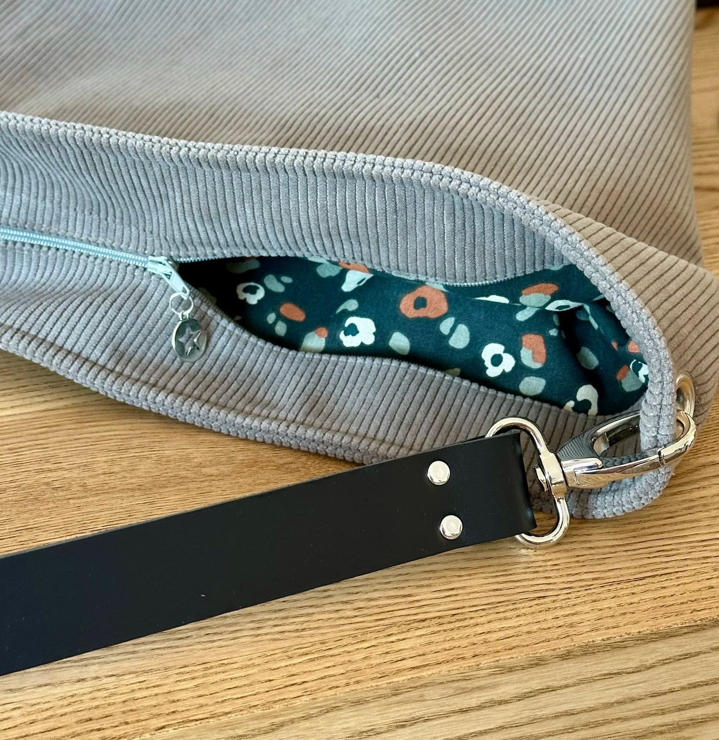Le sac hobo en velours cotelé taupe avec fermeture éclair.
