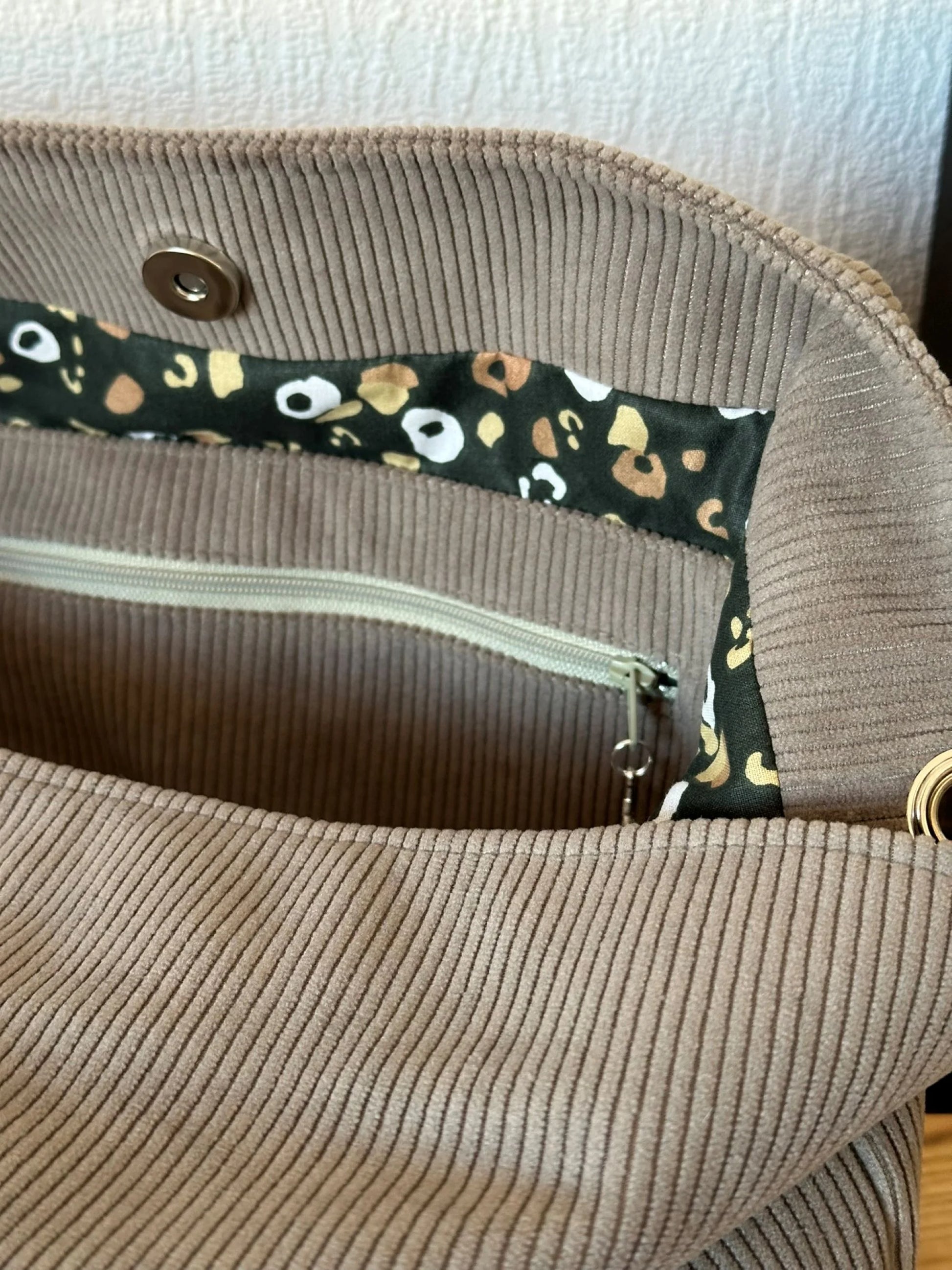 La poche intérieure zippée du sac Hobo en velours cotelé taupe.