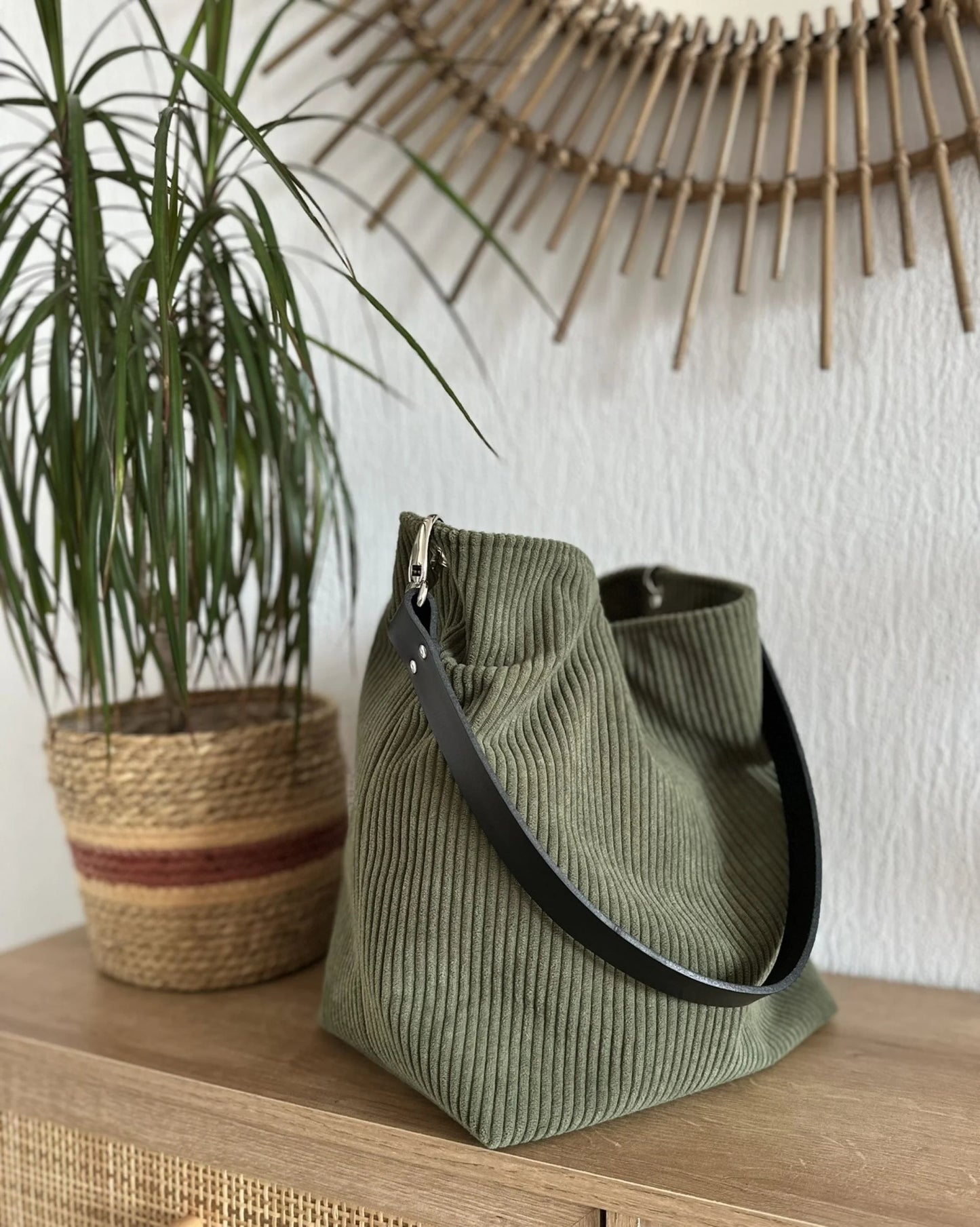 Vue d'ensemble du sac Hobo en velours cotelé vert armée et son anse en cuir noir amovible.