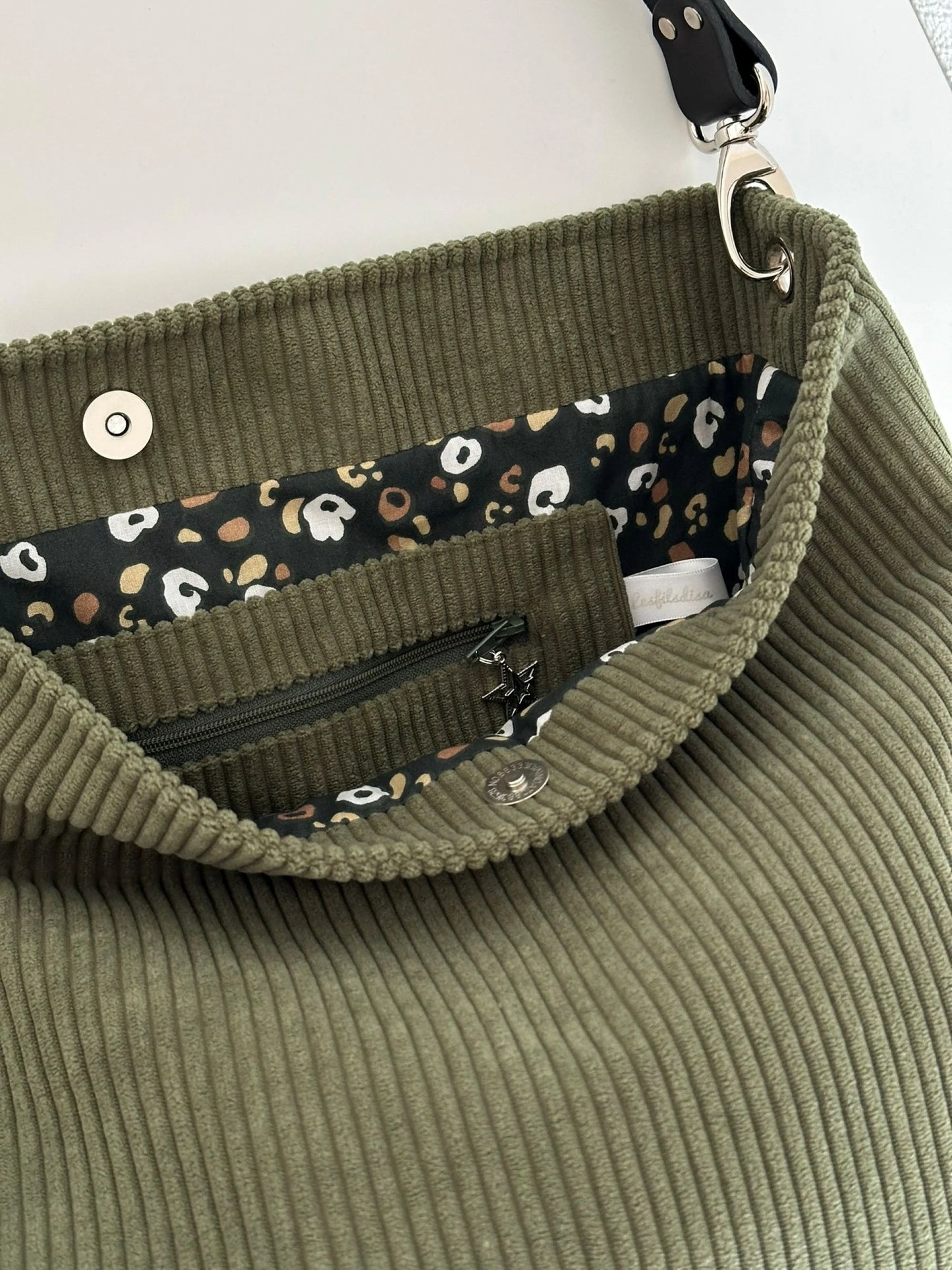 La poche intérieure zippée du sac Hobo en velours cotelé vert armée.