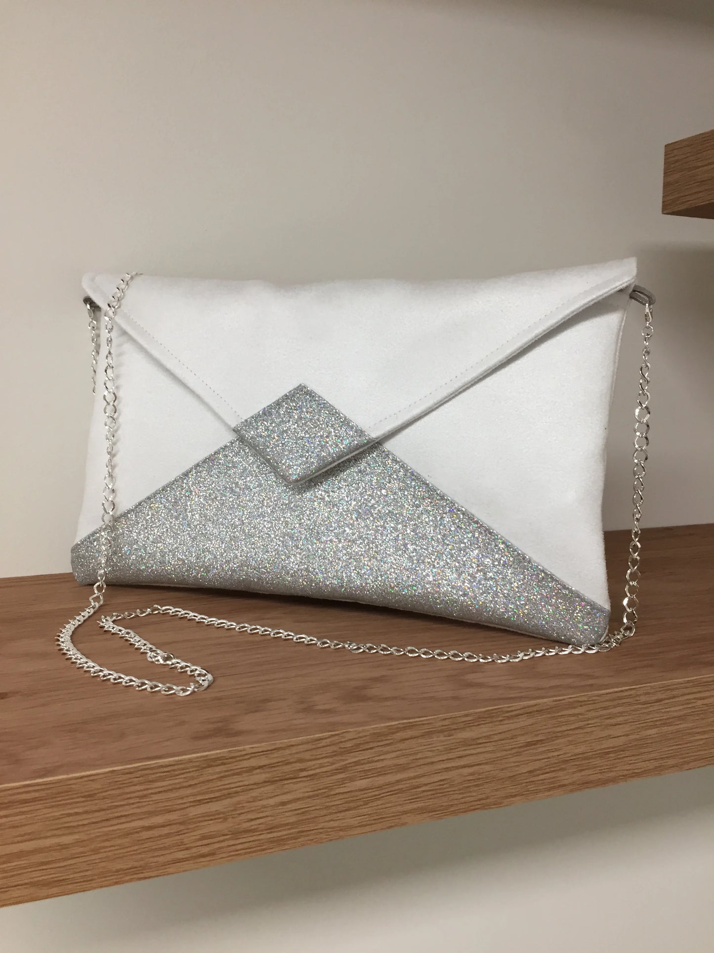 Le sac pochette Isa blanc à paillettes argentées avec chainette amovible