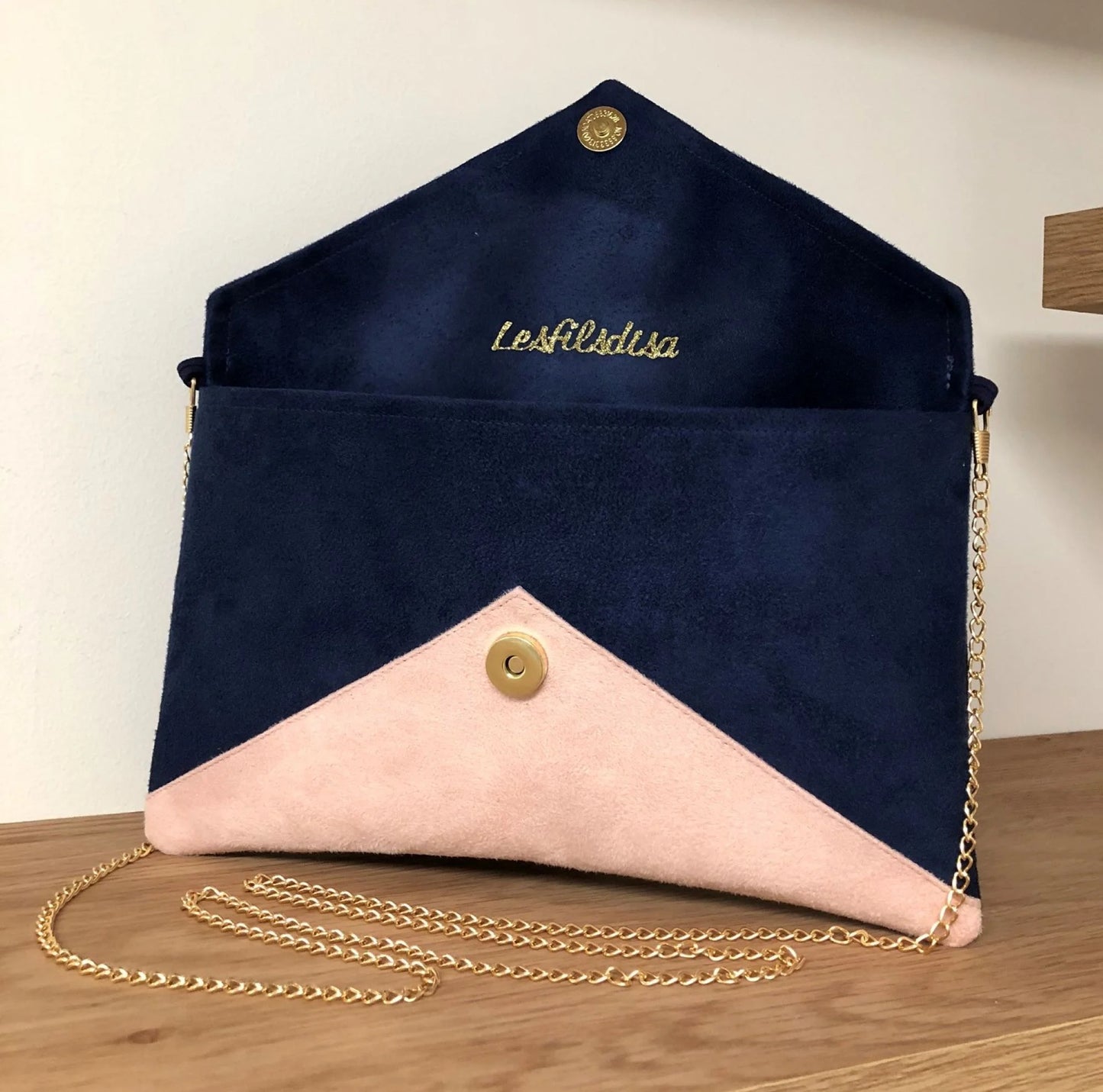 Le sac pochette Isa bleu marine et beige nude à paillettes dorées, ouvert.