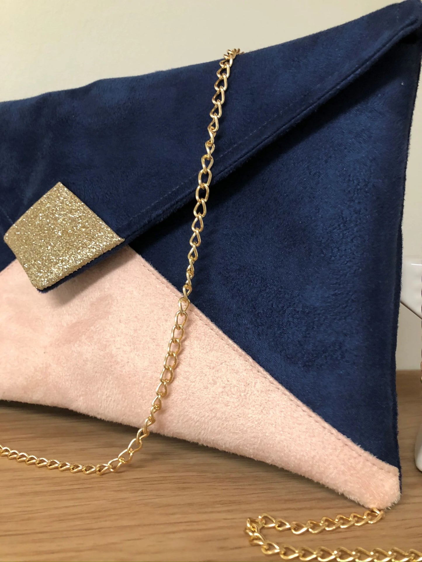 Vue détaillée du sac pochette Isa bleu marine et beige nude à paillettes dorées, en face avant.