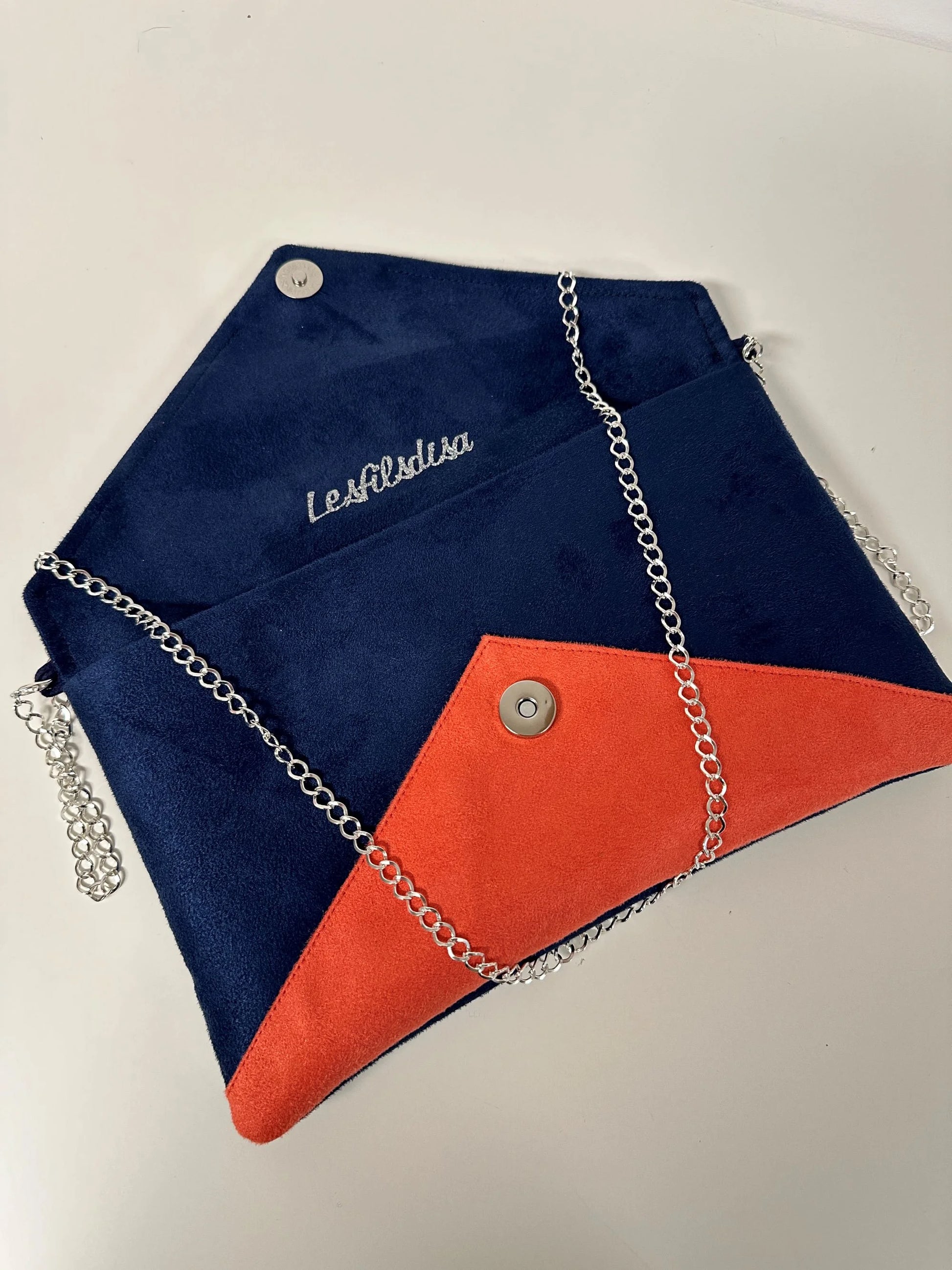 Le sac pochette Isa bleu marine et corail à paillettes argentées, avec chainette amovible, ouvert.