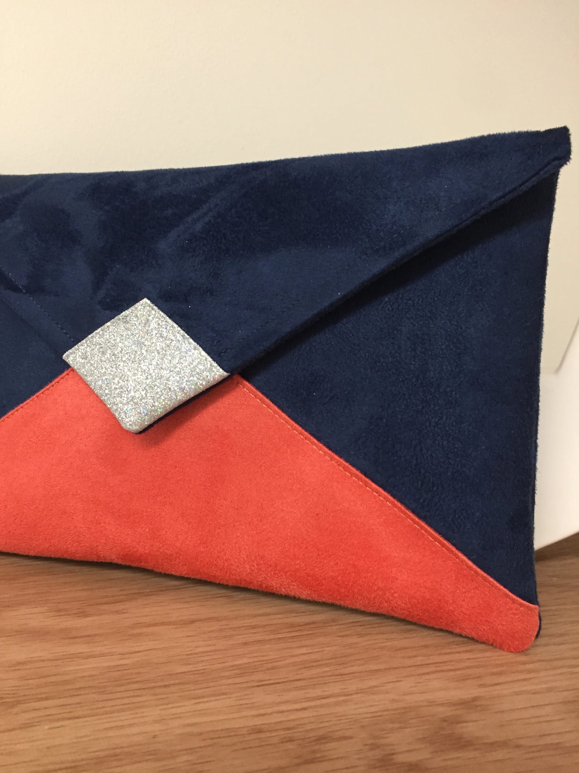 Le sac pochette Isa bleu marine et corail à paillettes argentées, sans chainette amovible