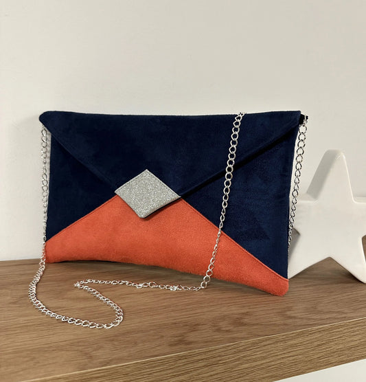 Le sac pochette Isa bleu marine et corail à paillettes argentées, avec chainette amovible.