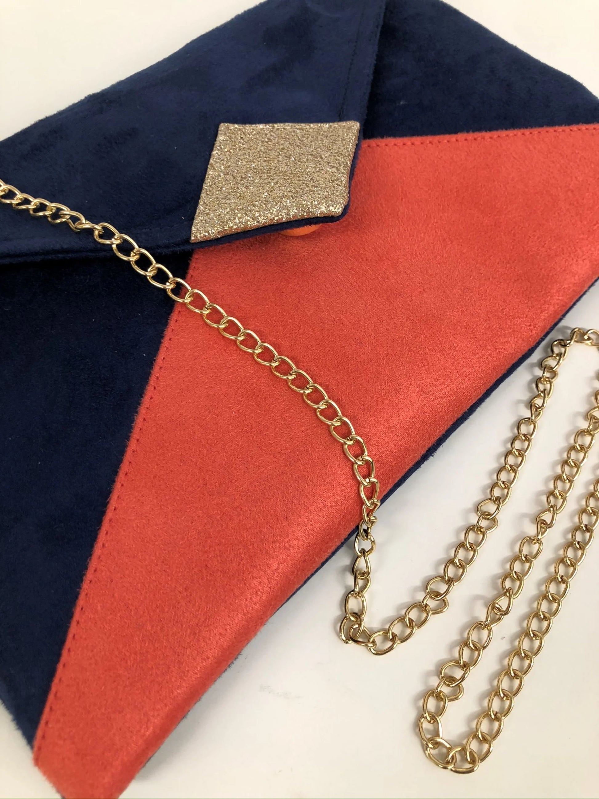 Vue détaillée du sac pochette Isa bleu marine et corail à paillettes dorées.