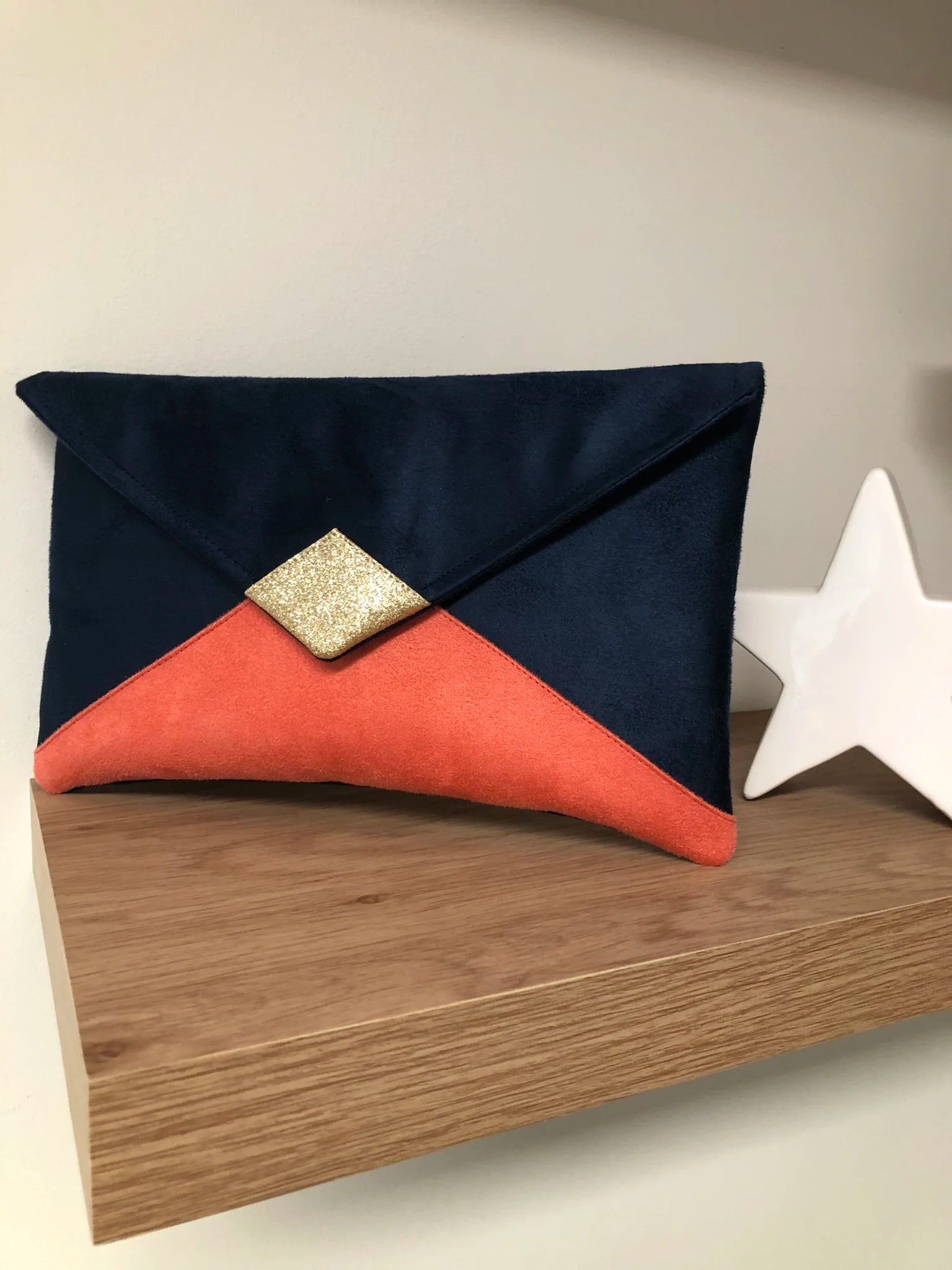 Le sac pochette Isa bleu marine et corail à paillettes dorées, sans chainette.