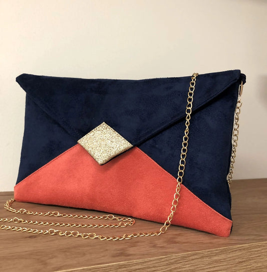 Le sac pochette Isa bleu marine et corail à paillettes dorées.