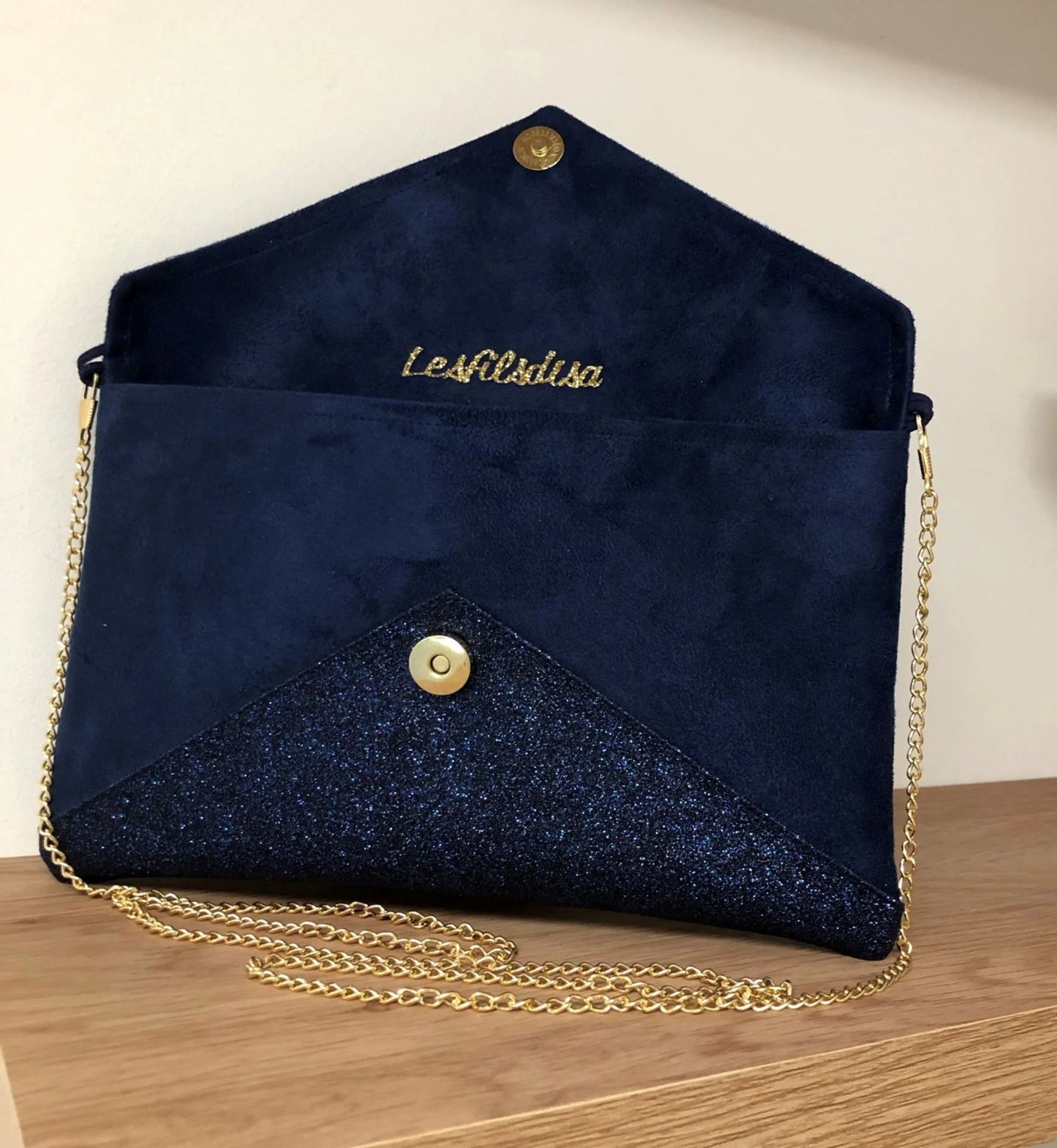 Le sac pochette Isa bleu marine et doré à paillettes, avec chainette amovible, ouvert.