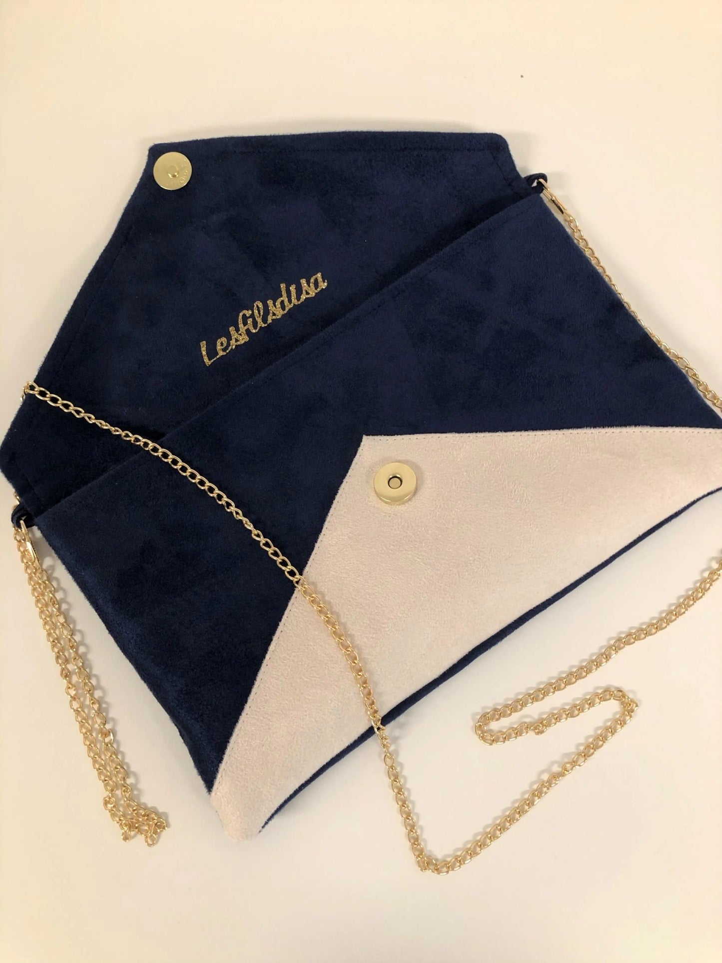 Le sac pochette Isa bleu marine et écru à paillettes dorées, ouvert.