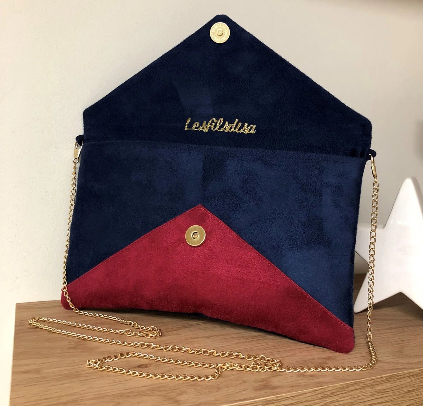 Le sac pochette Isa bleu marine et fuchsia à paillettes dorées, ouvert.