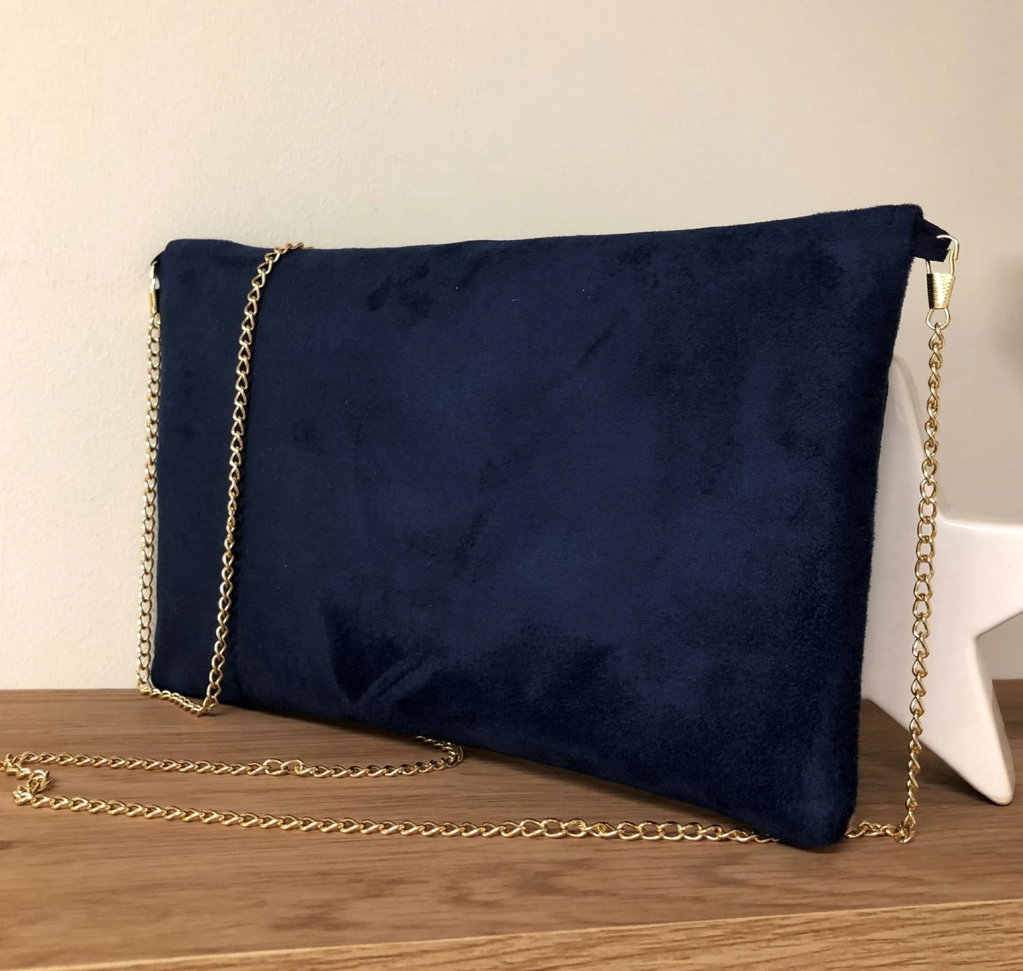 Vue arrière du sac pochette Isa bleu marine et fuchsia à paillettes dorées, avec chainette amovible.
