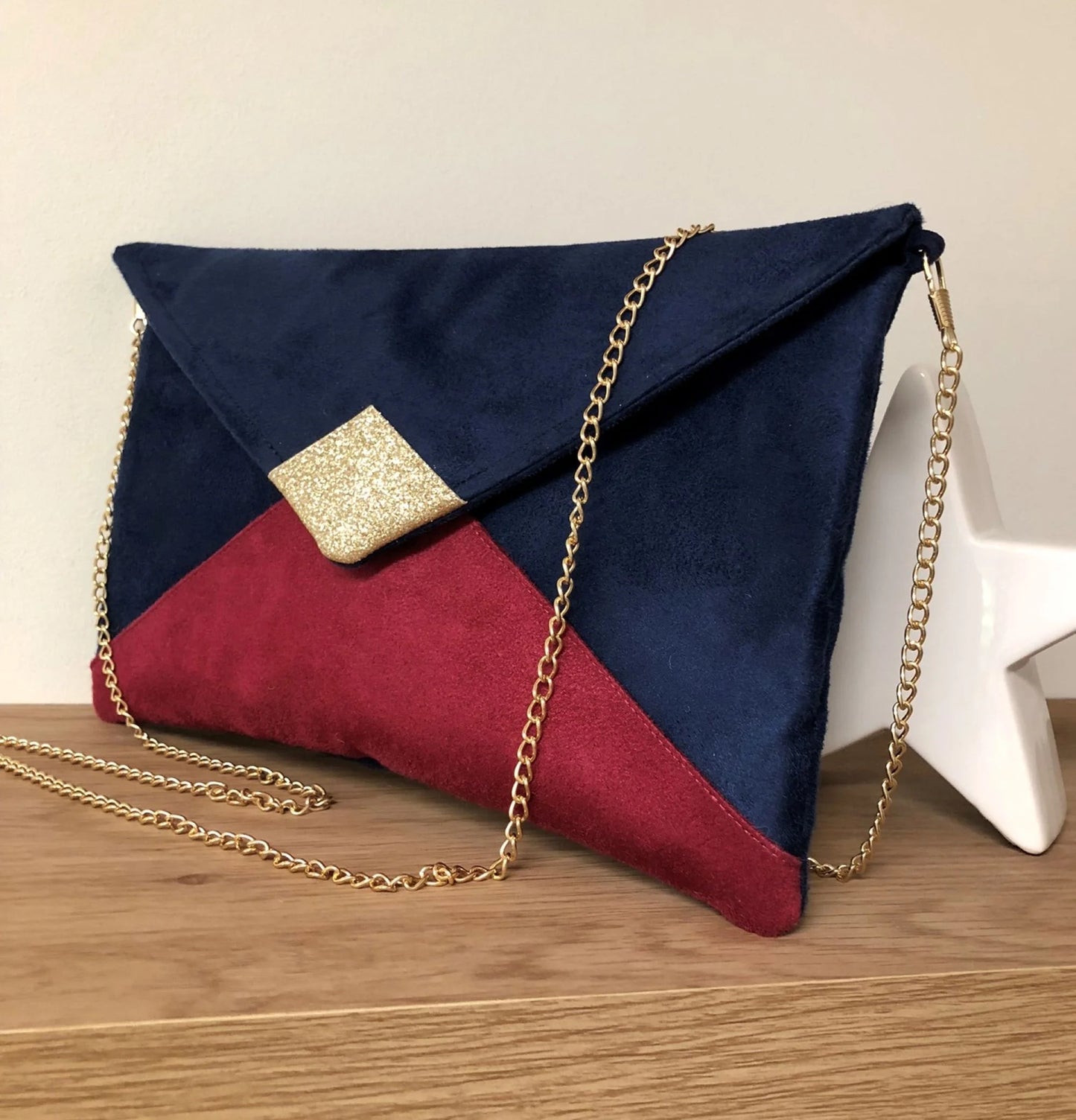 Le sac pochette Isa bleu marine et fuchsia à paillettes dorées, avec chainette amovible, face avant.