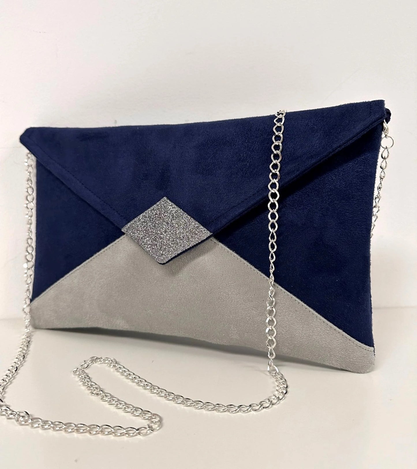 sac pochette Isa bleu marine et gris à paillettes argentées, avec sa chainette amovible, vue de face.