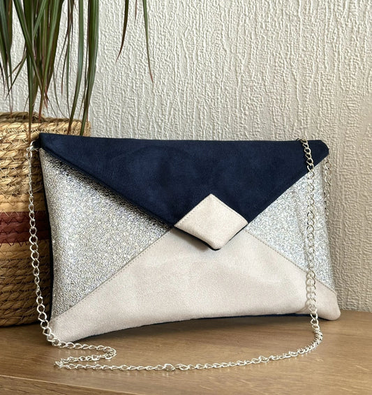 Le sac pochette Isa bleu marine, ivoire et argenté avec sa chainette amovible.