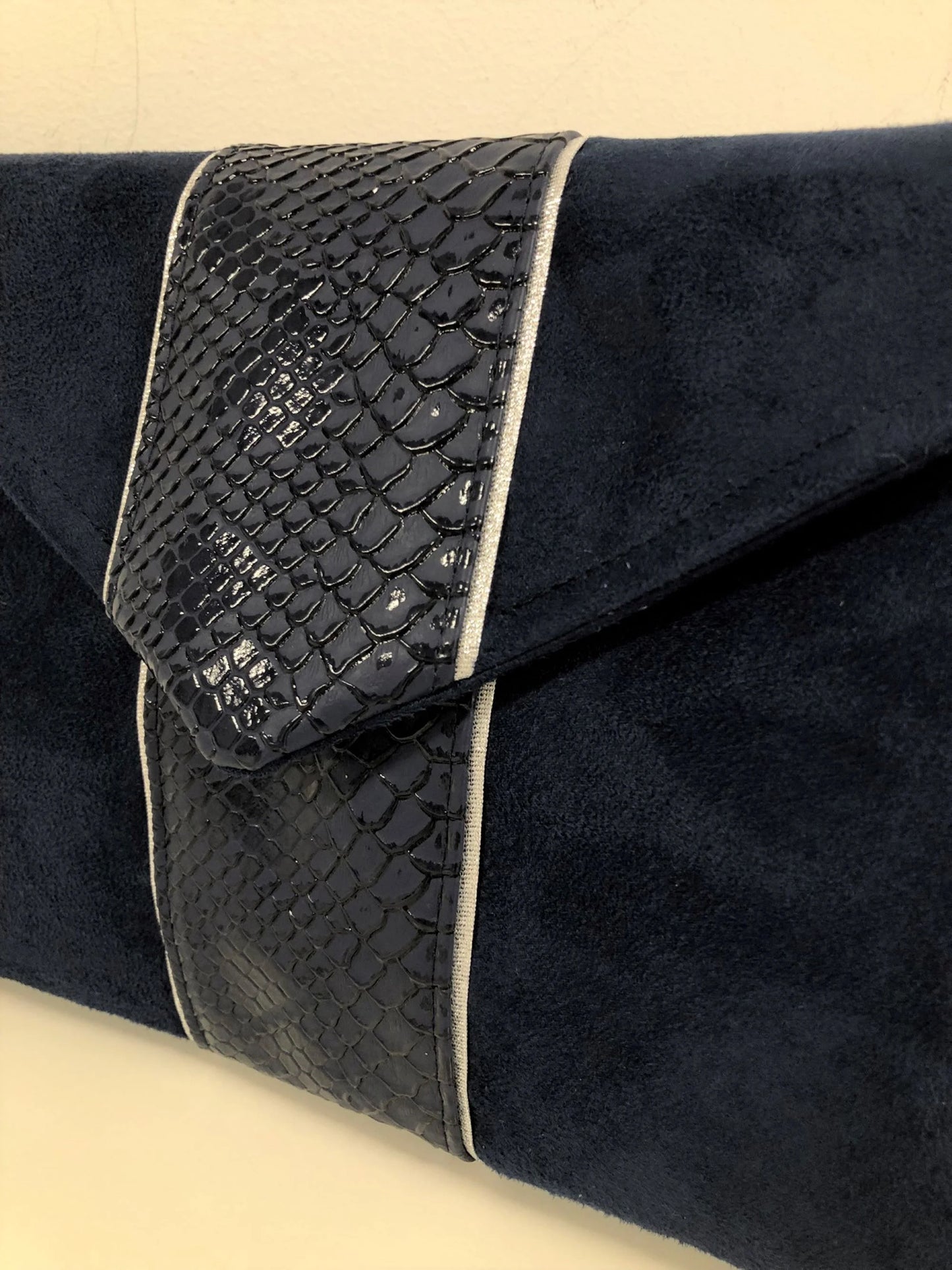 Vue détaillée du sac pochette Isa bleu marine reptile à liseré argenté.