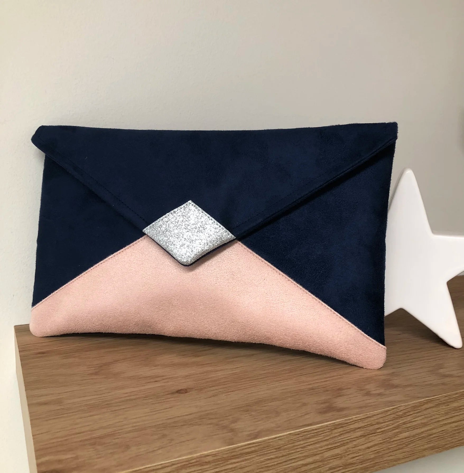 Le sac pochette Isa bleu marine et rose poudré à paillettes argentées, sans chainette amovible.