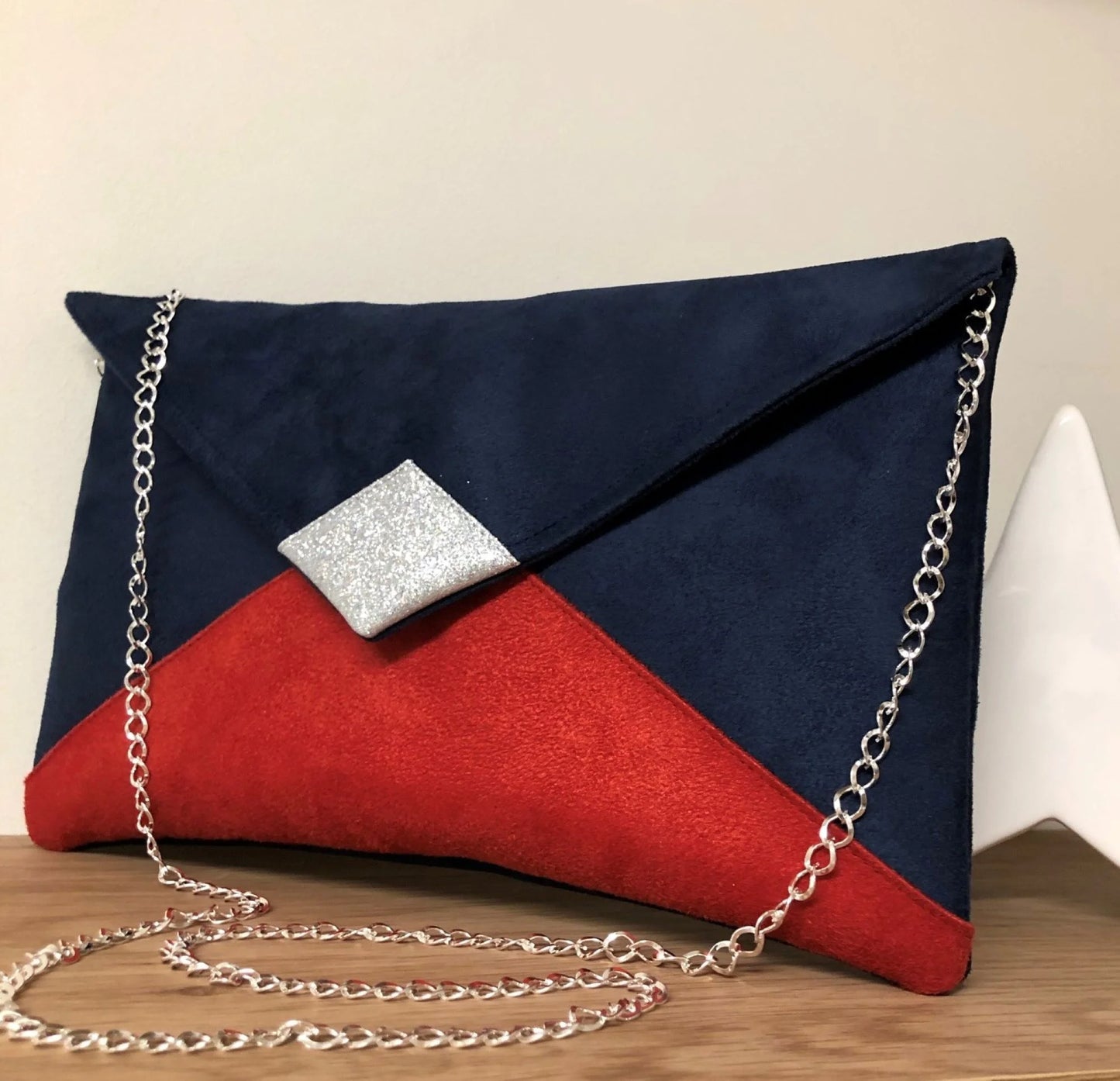 Le sac pochette Isa bleu marine et rouge à paillettes argentées, face avant.