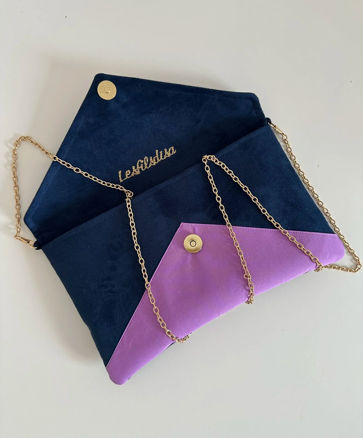 Le sac pochette Isa bleu marine violet et doré avec sa chainette dorée amovible, ouvert.